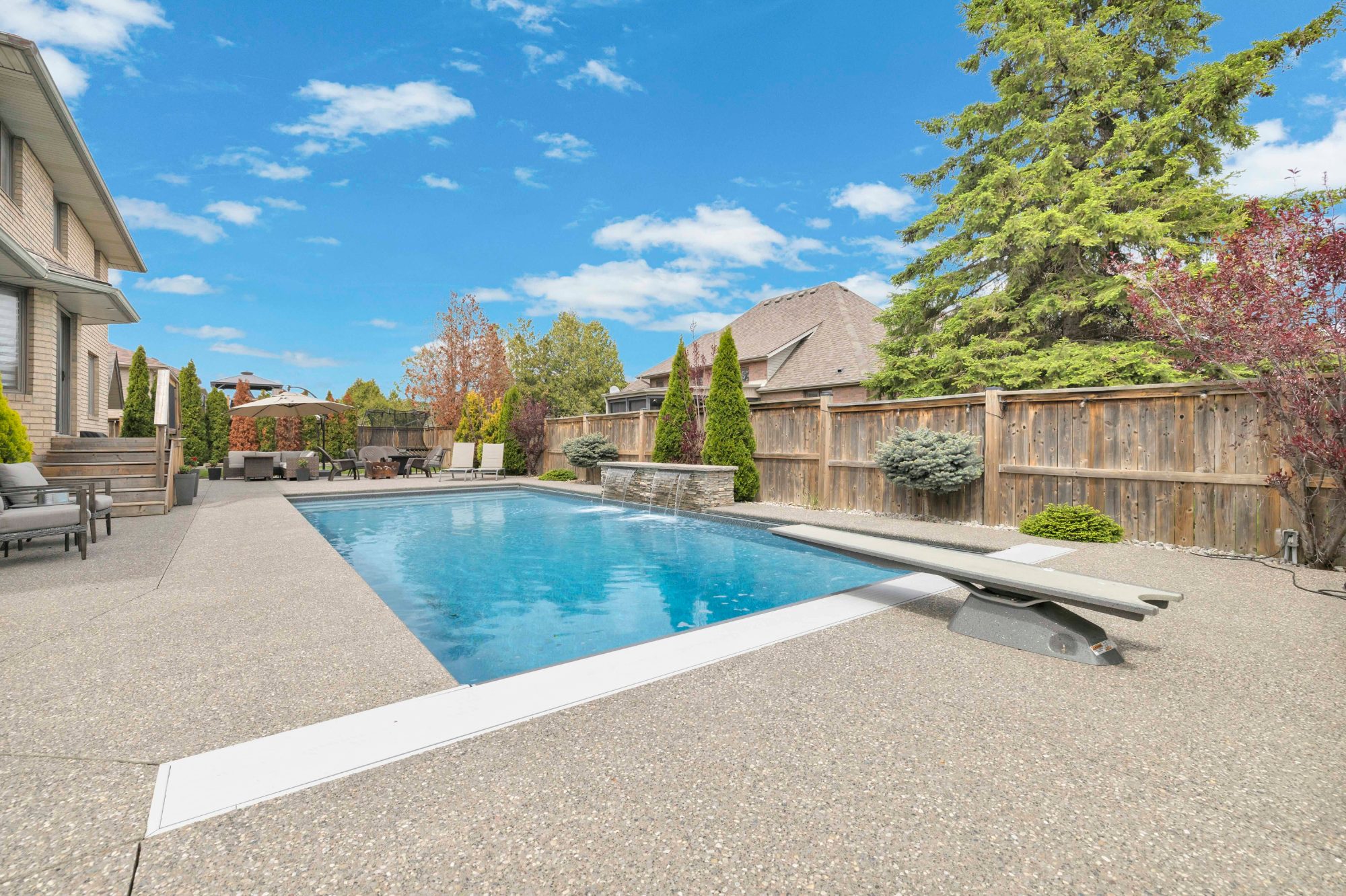 Inground pool with diving board and cascading waterfall