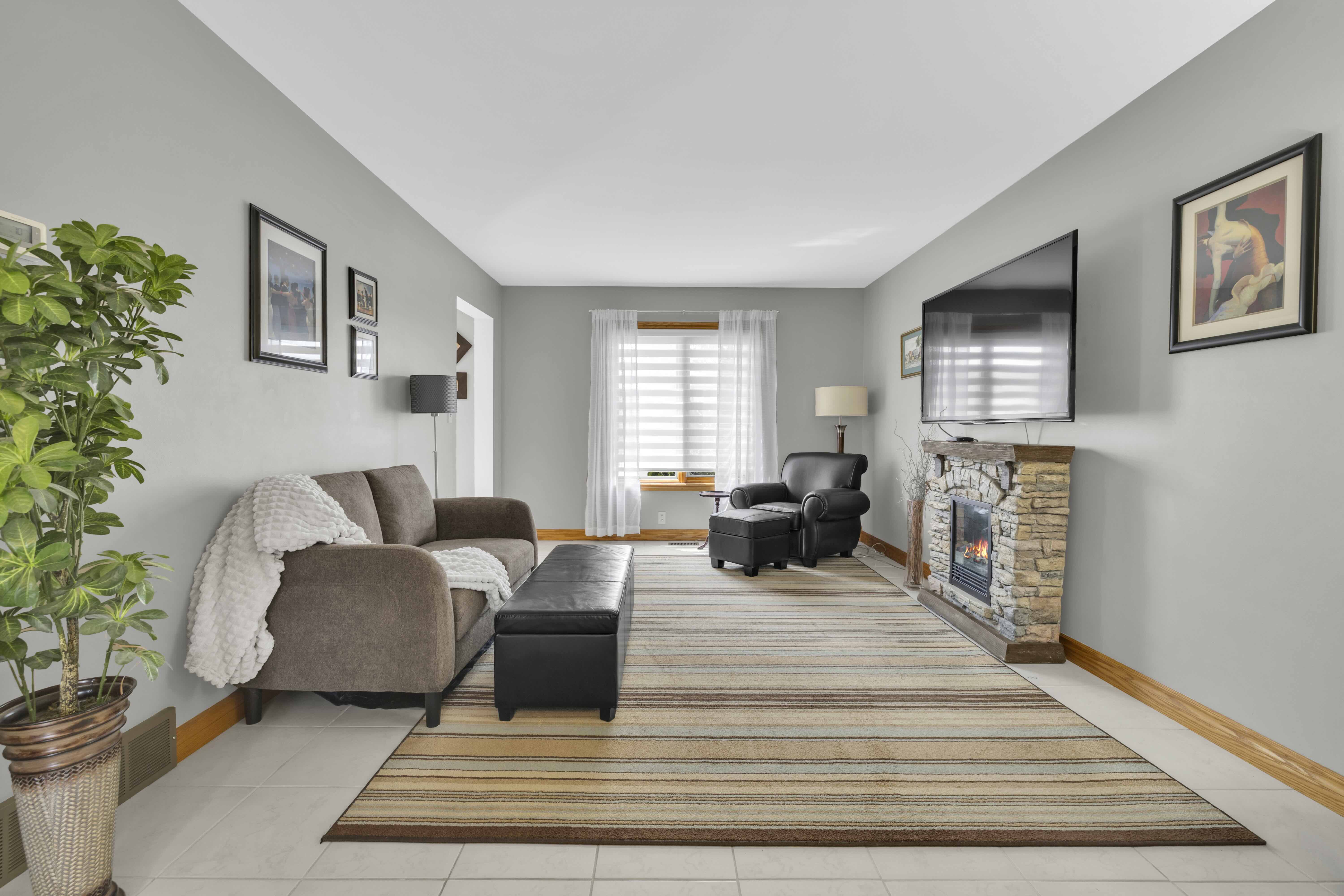 Living room with stone fireplace and mounted TV