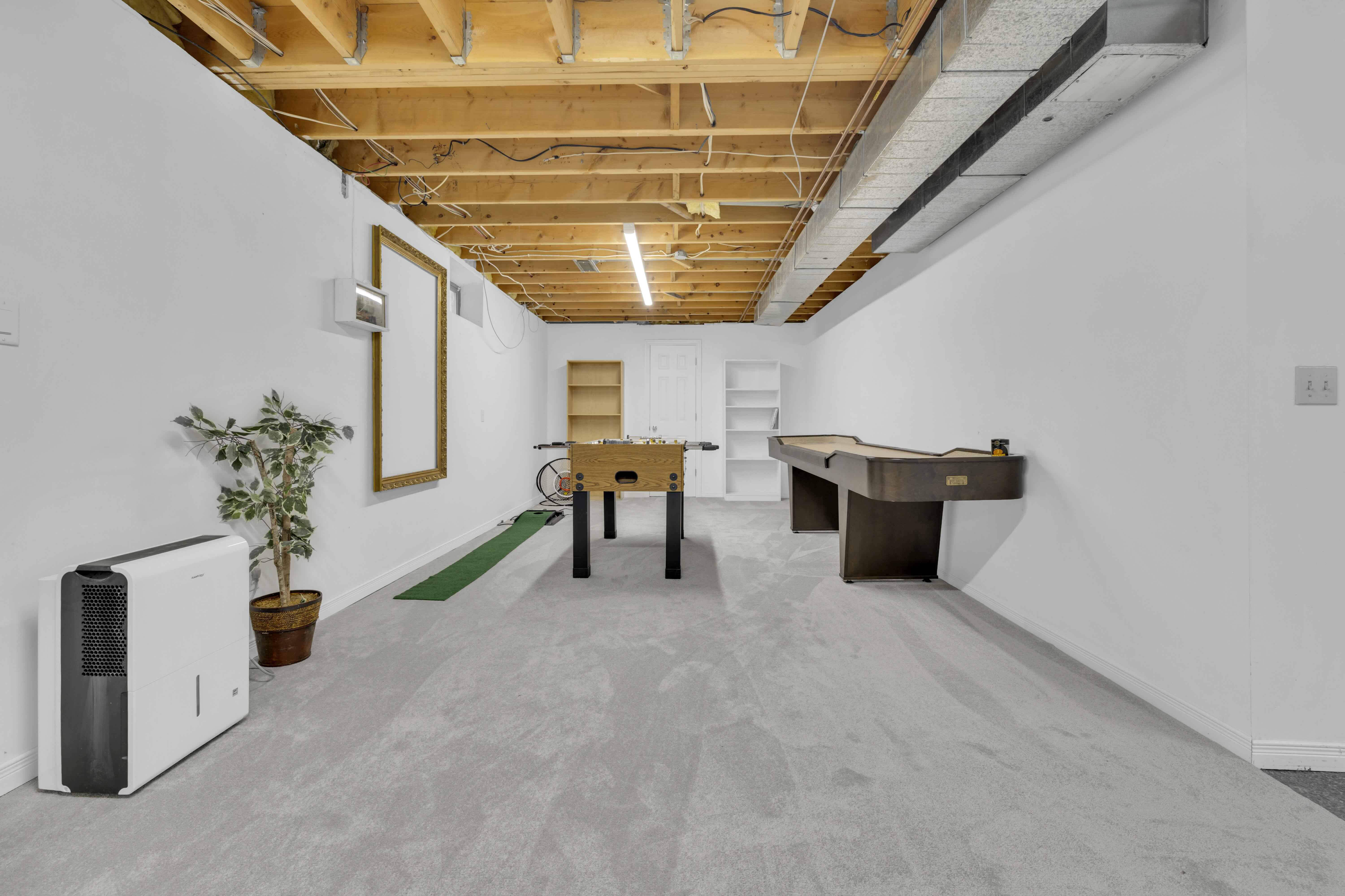 Basement games room with foosball, pool table and putting green