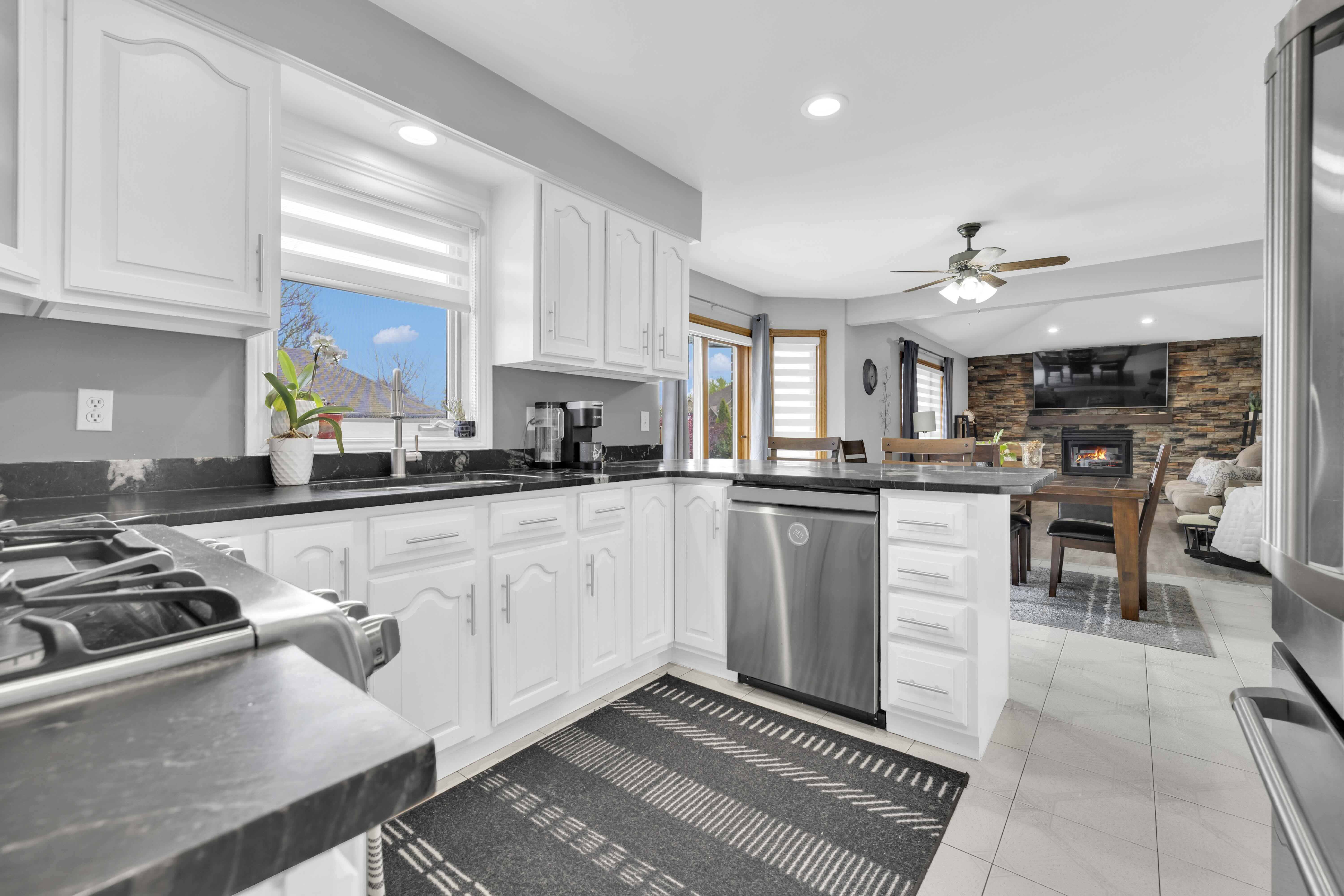 Kitchen sink window, stainless appliances, open view to living area