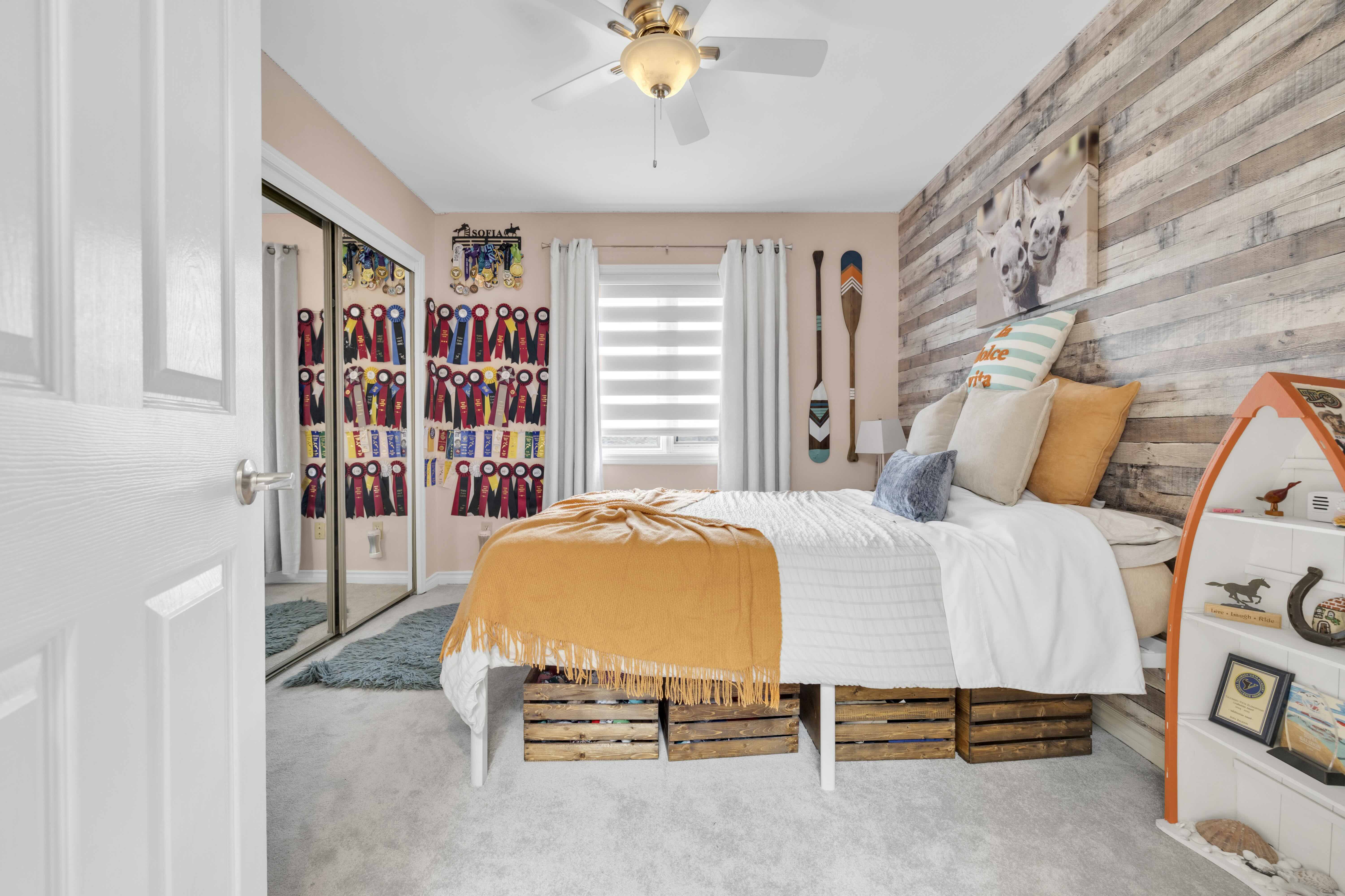 Bedroom with wood accent wall and mirrored closet doors