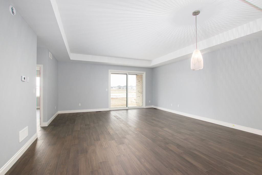Living room with tray ceiling detail and sliding glass door to backyard