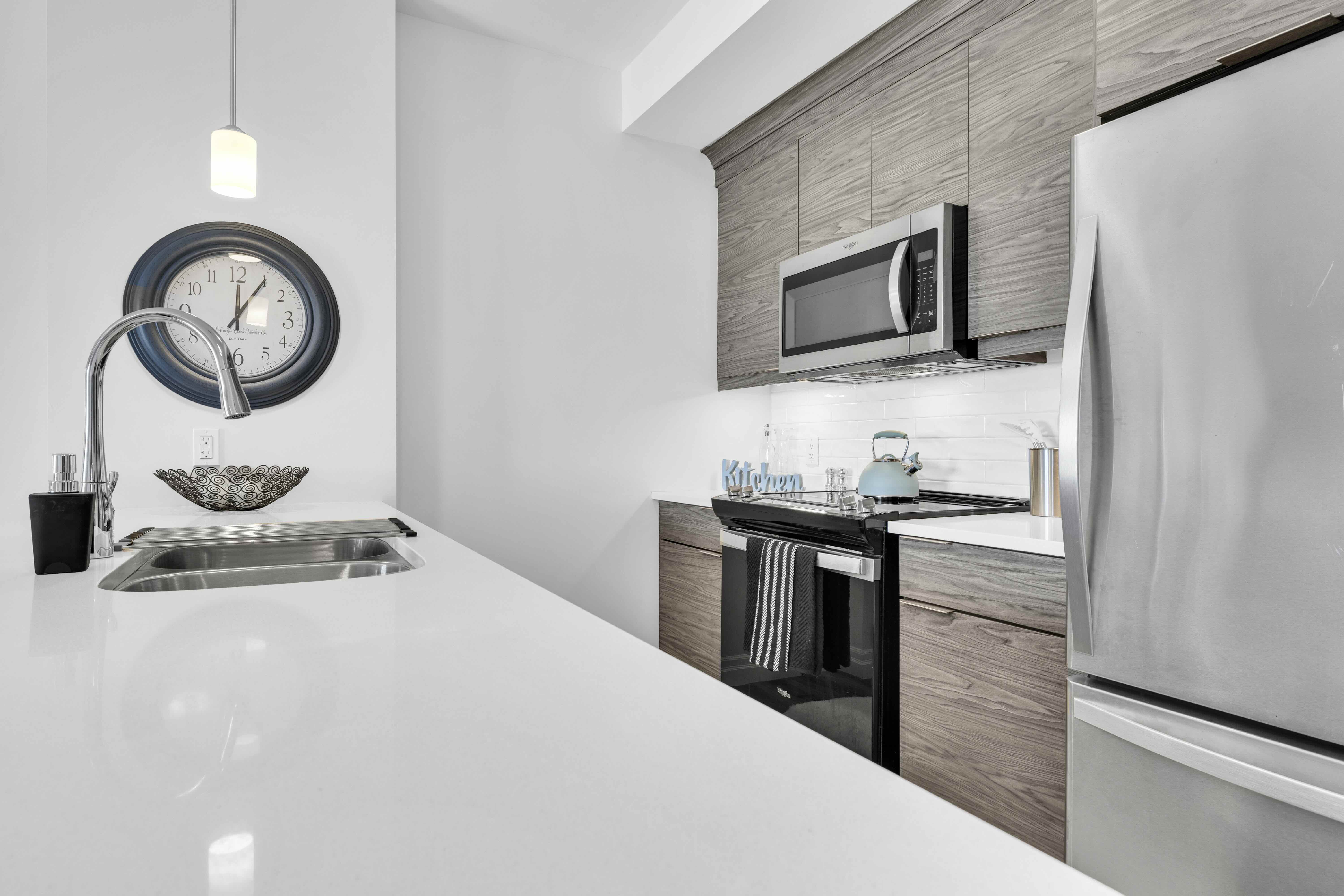 Kitchen countertop, sink, stove, and microwave close-up