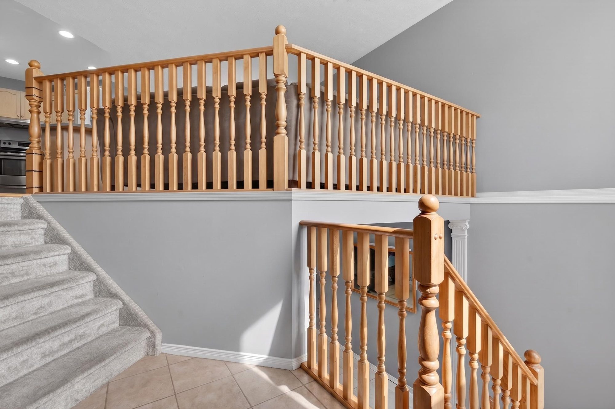 Carpeted staircase with wooden railing