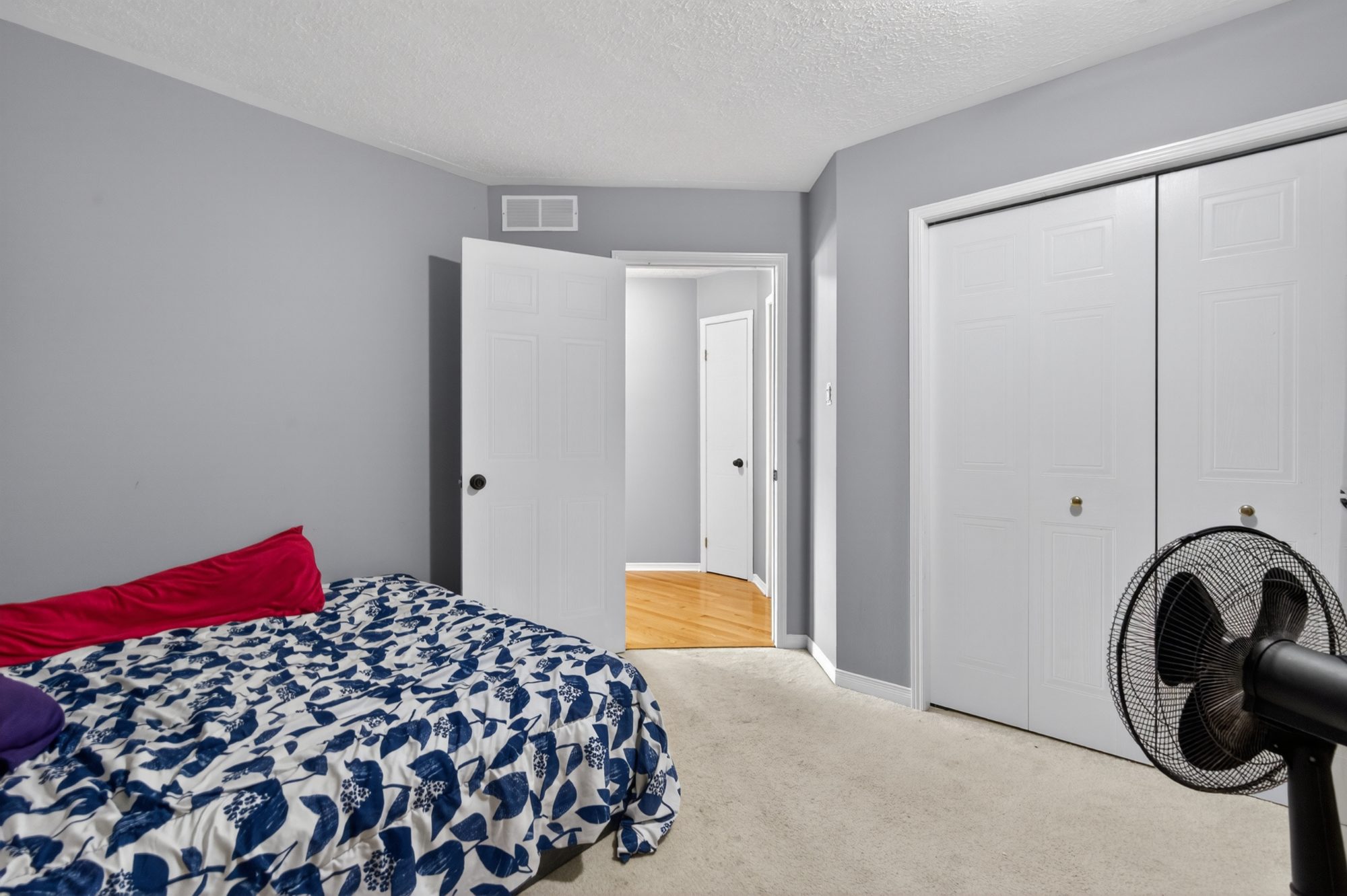 Bedroom with double closet doors and carpeted floor