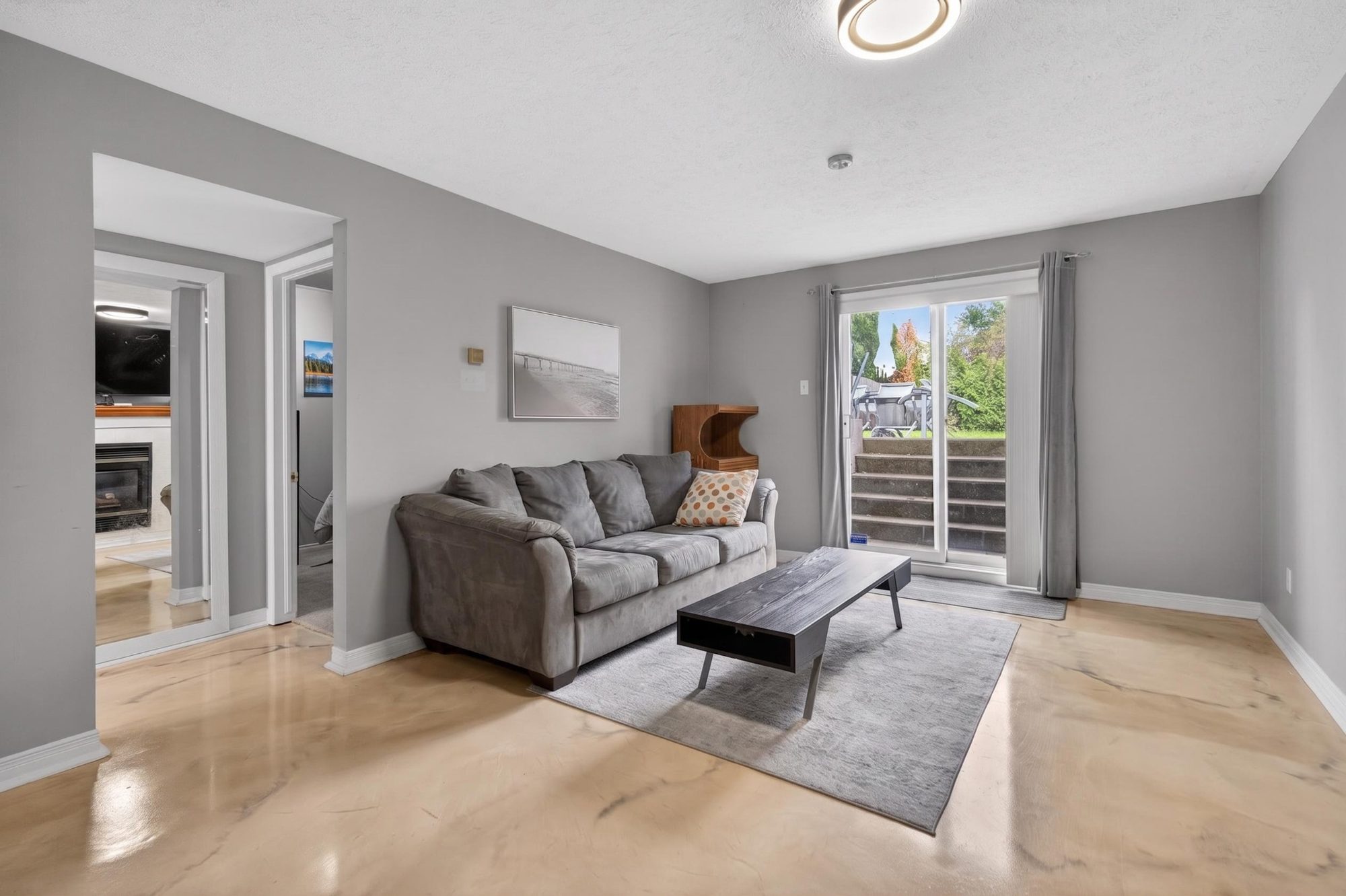 Lower level living room with grey couch and sliding door