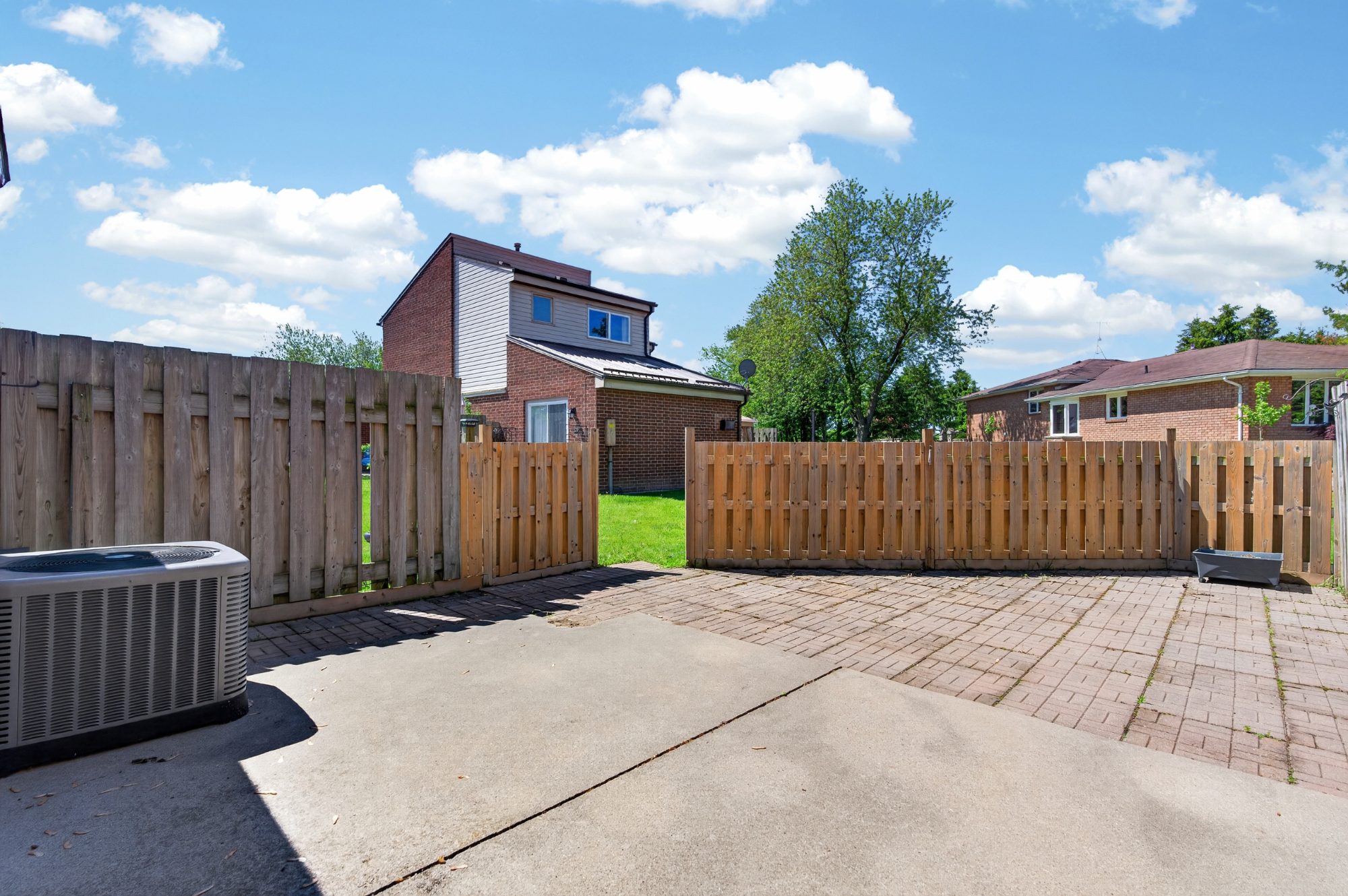 Fenced backyard with concrete patio and lawn