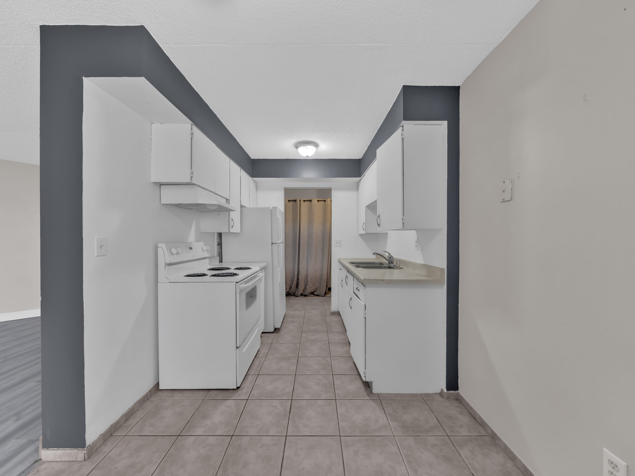 Kitchen with white cabinetry and tiled floor