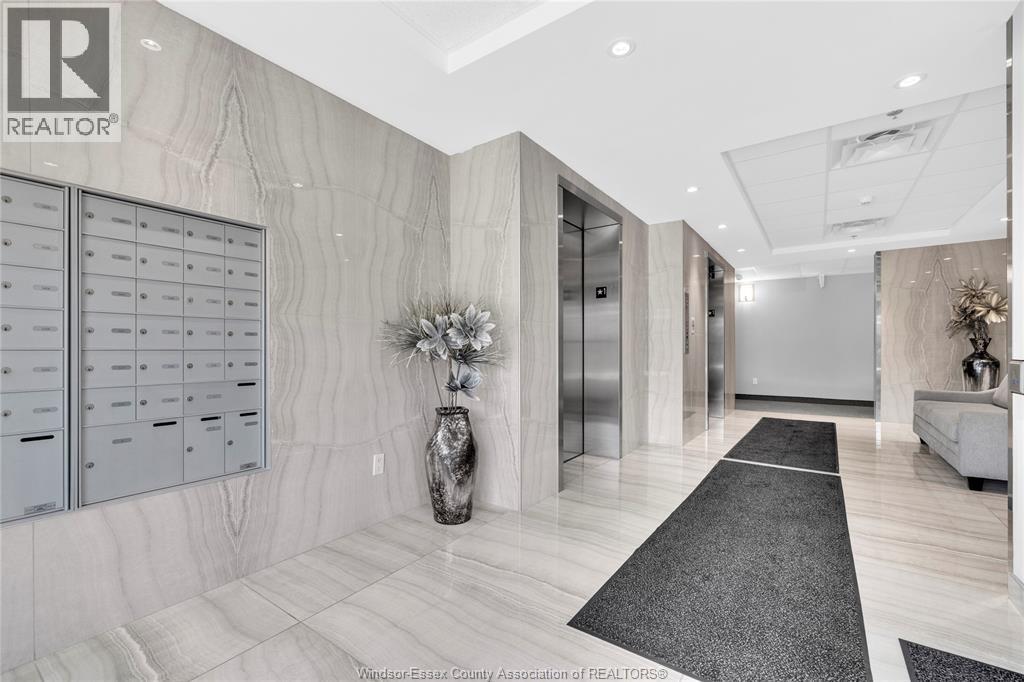 Building lobby with patterned wall cladding, mailboxes, and two stainless elevators