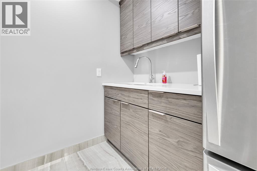 Common kitchenette area with cabinetry and sink