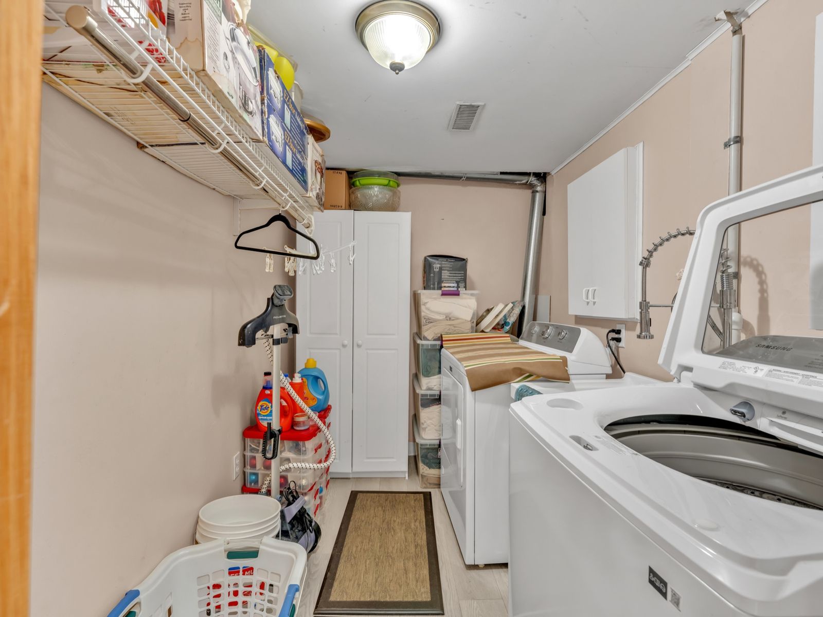 The laundry room with washer, dryer and storage cabinets.