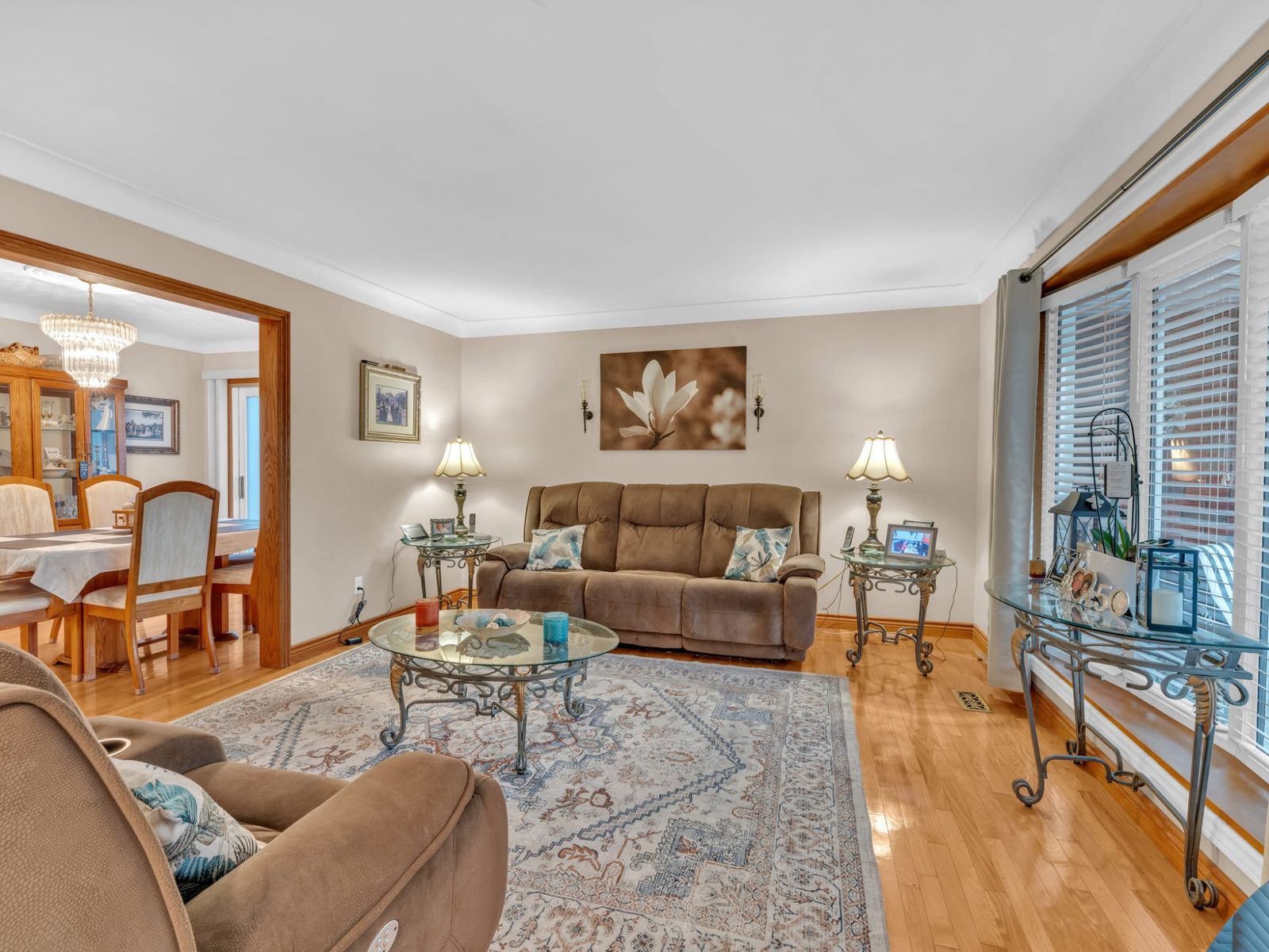 The living room with a large window, sofa and armchair.