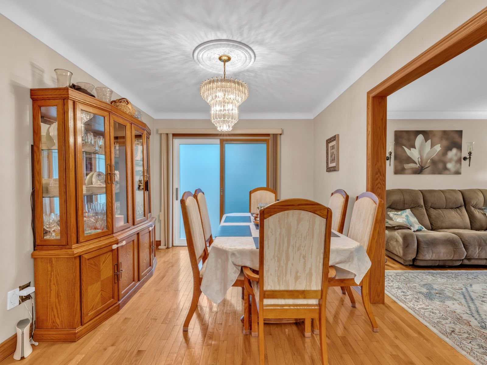 The dining room with a wood table for six, china cabinet and chandelier.
