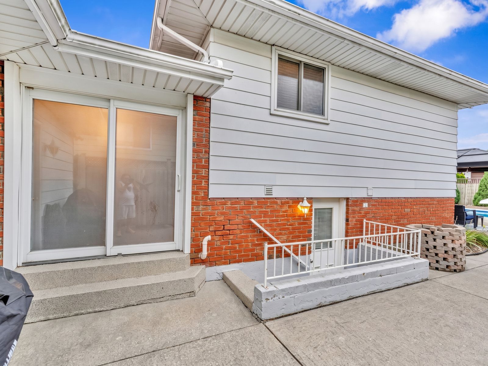 The rear of the house showing the sliding door and grade-level walkout.