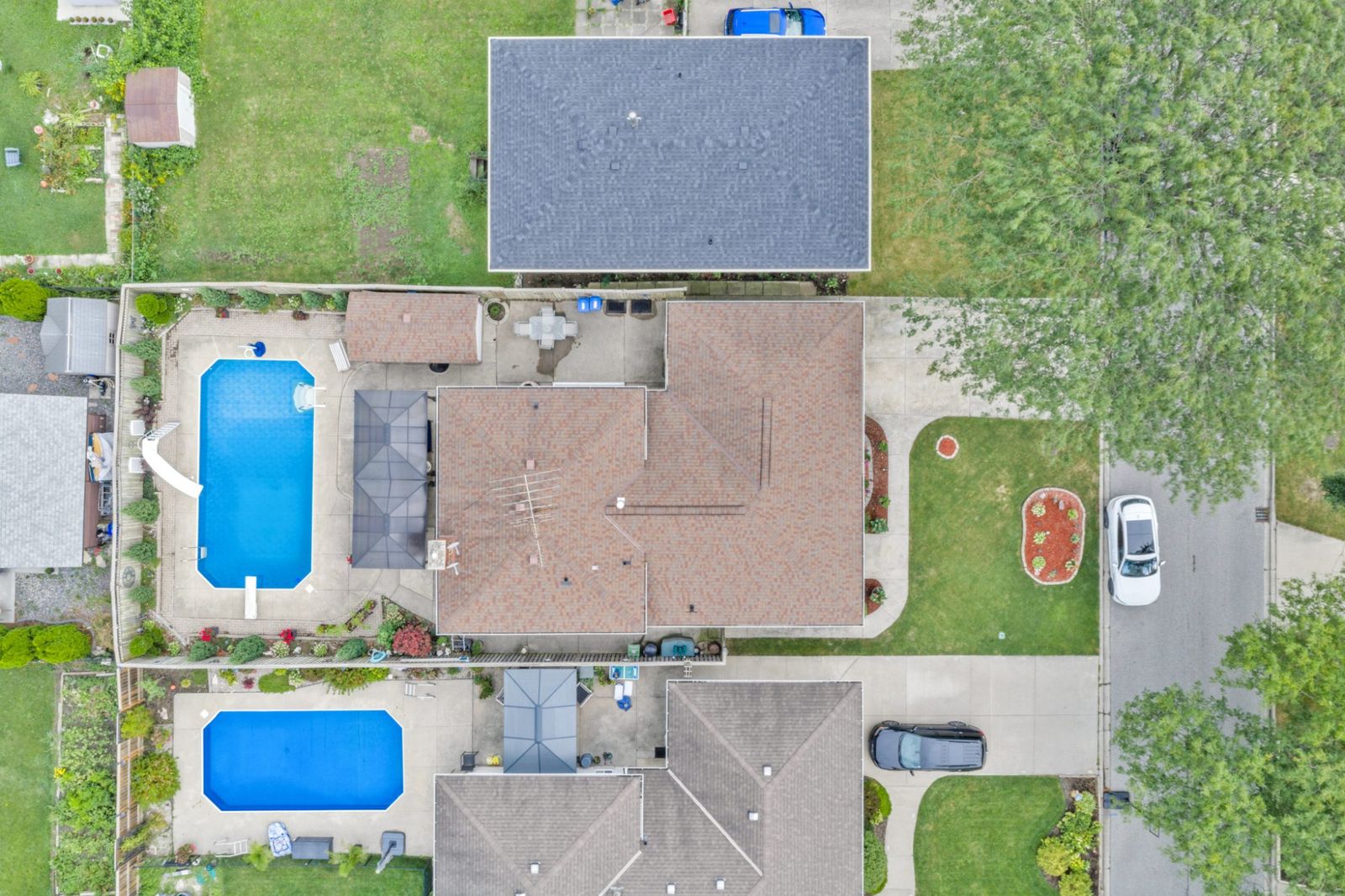 Aerial view of the property: the roof, the pool, both gazebos and the yard.