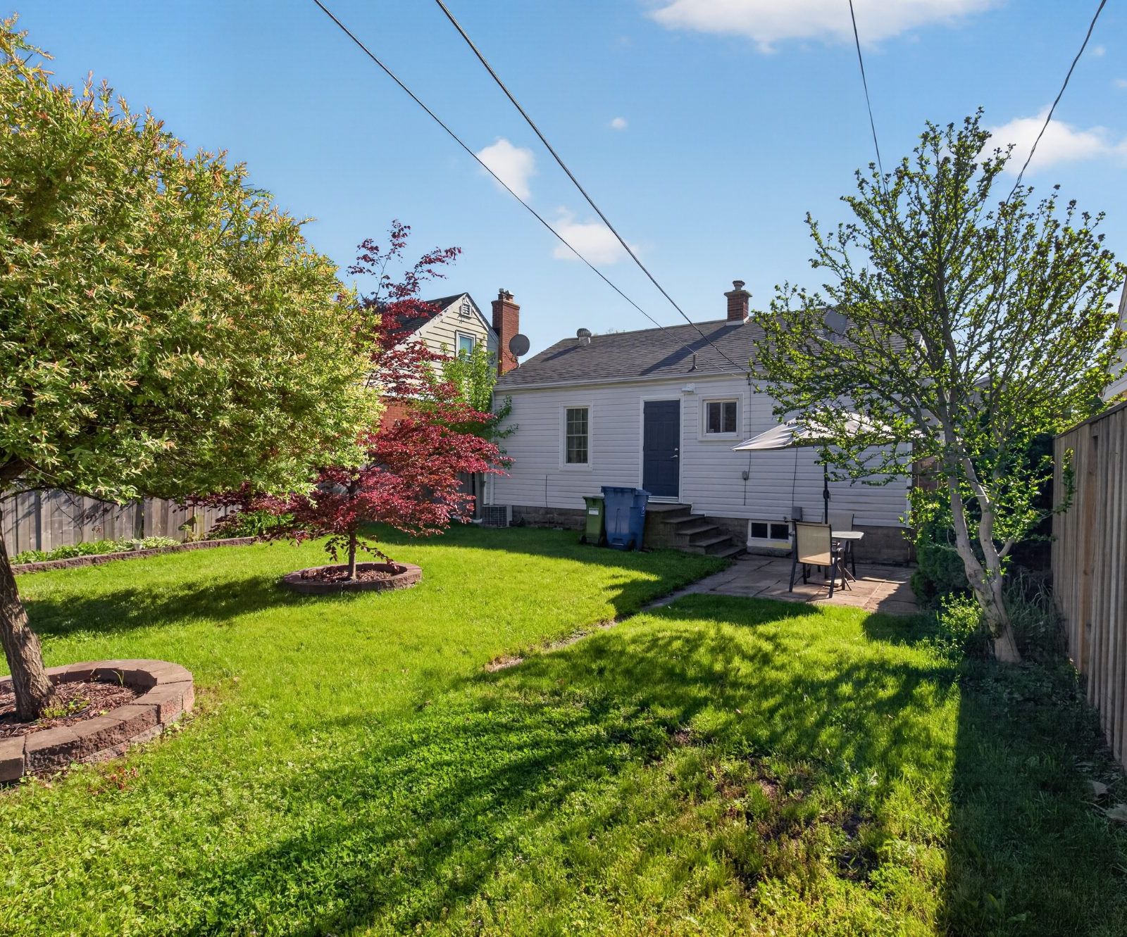 Backyard view of Windsor, ON with mature trees and back of house
