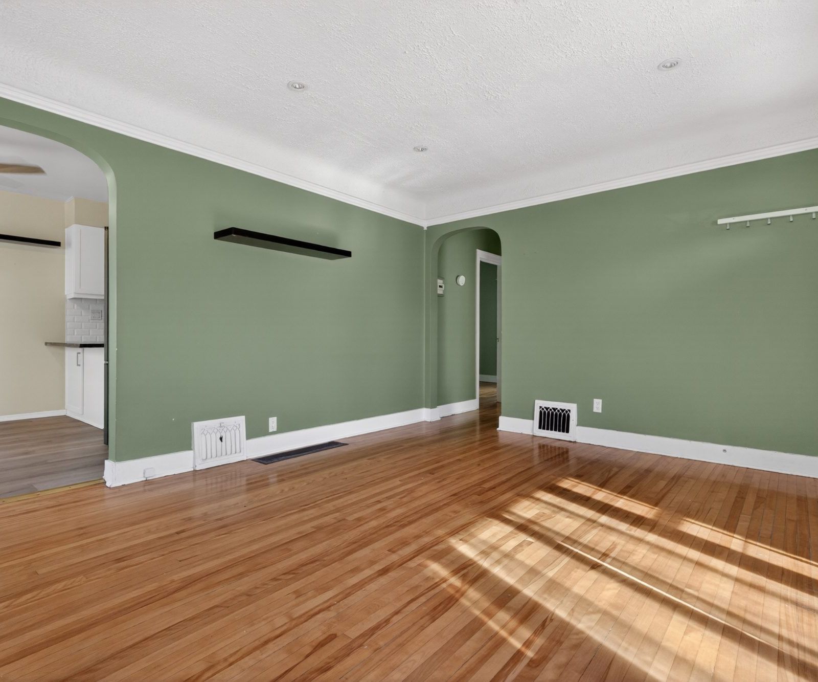 Living room with arched doorway to kitchen
