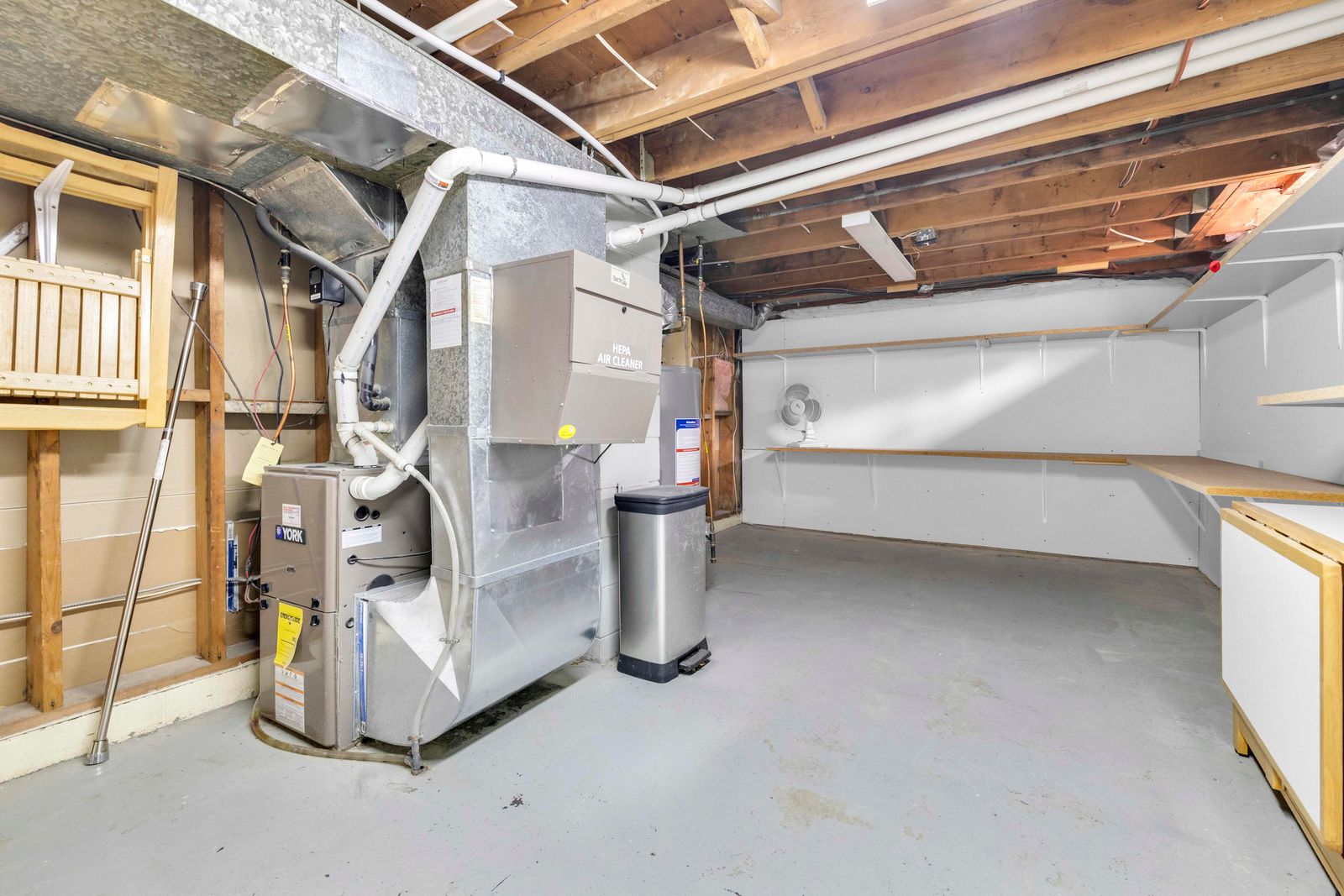Unfinished basement storage and mechanical area with furnace and water heater.