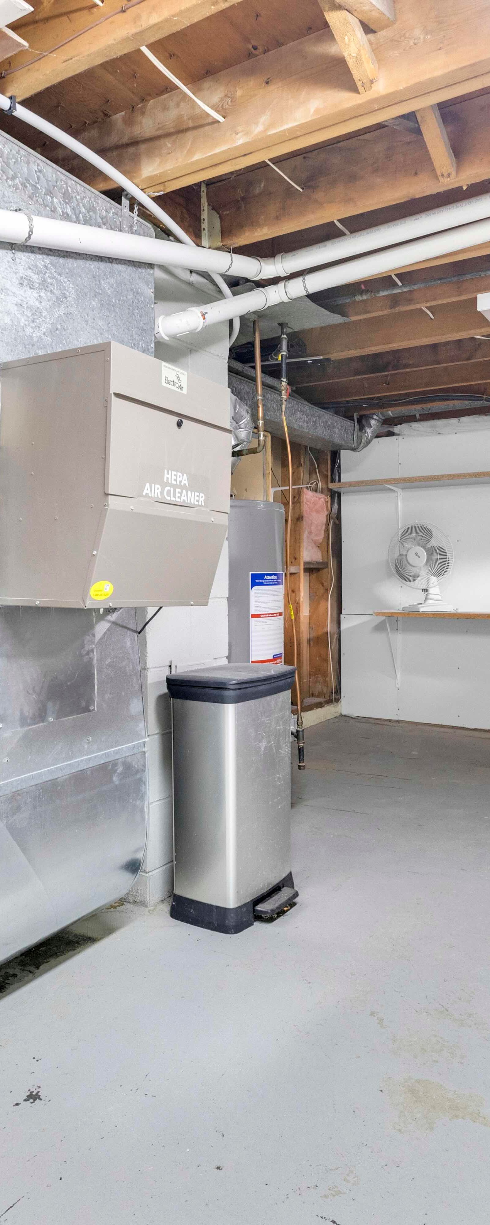 Unfinished basement storage and mechanical area with furnace and water heater.