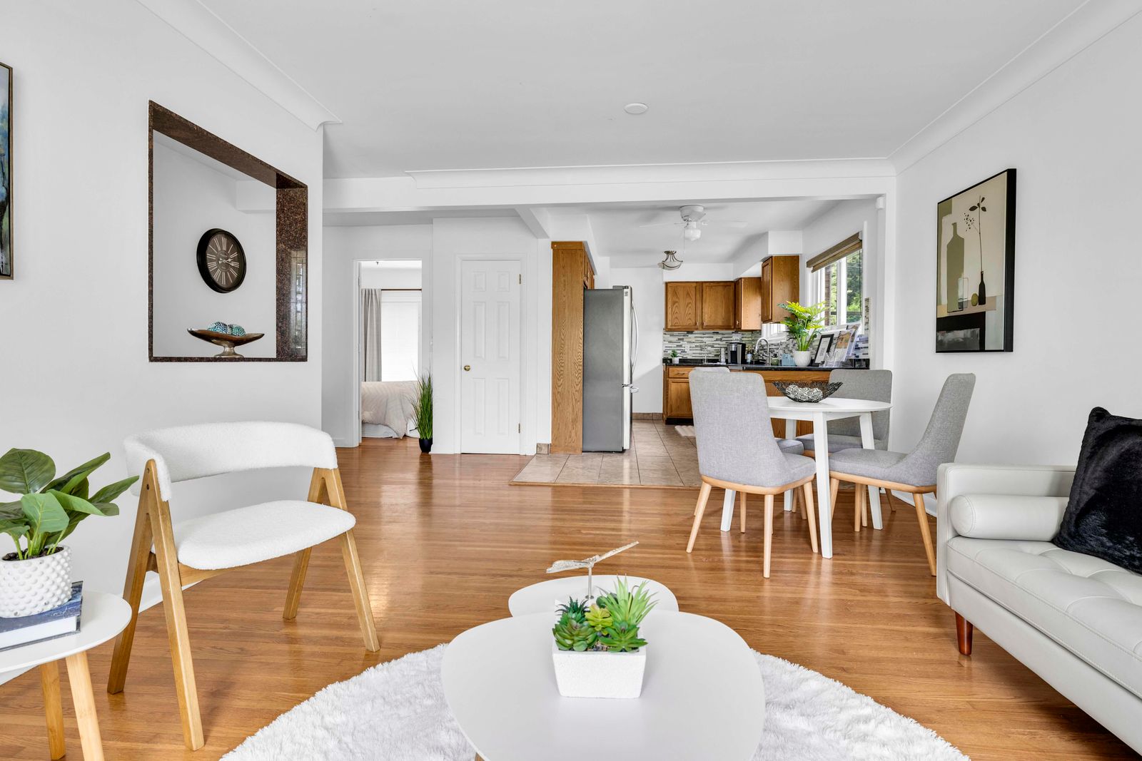 Open living room showing seating area, dining space, and kitchen with flooring.