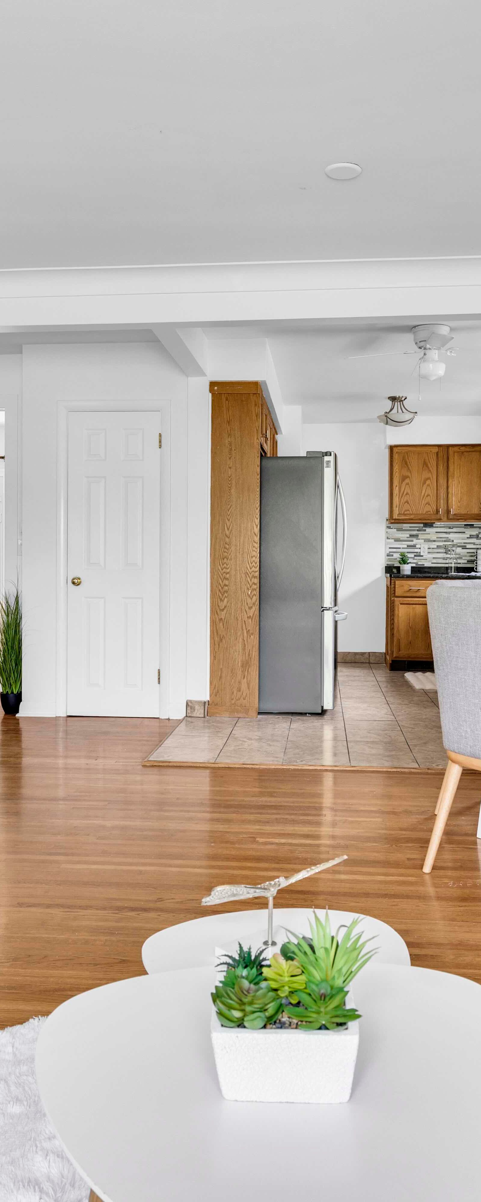 Open living room showing seating area, dining space, and kitchen with flooring.