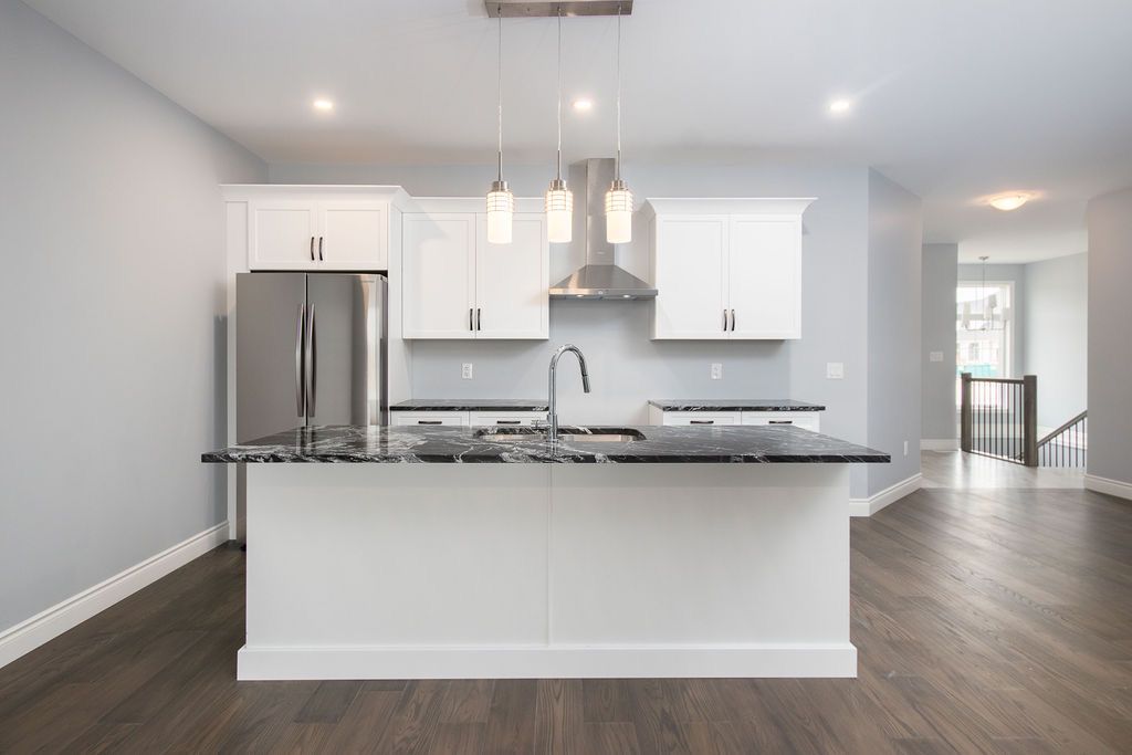 Kitchen — white cabinetry, stainless steel appliances, granite island