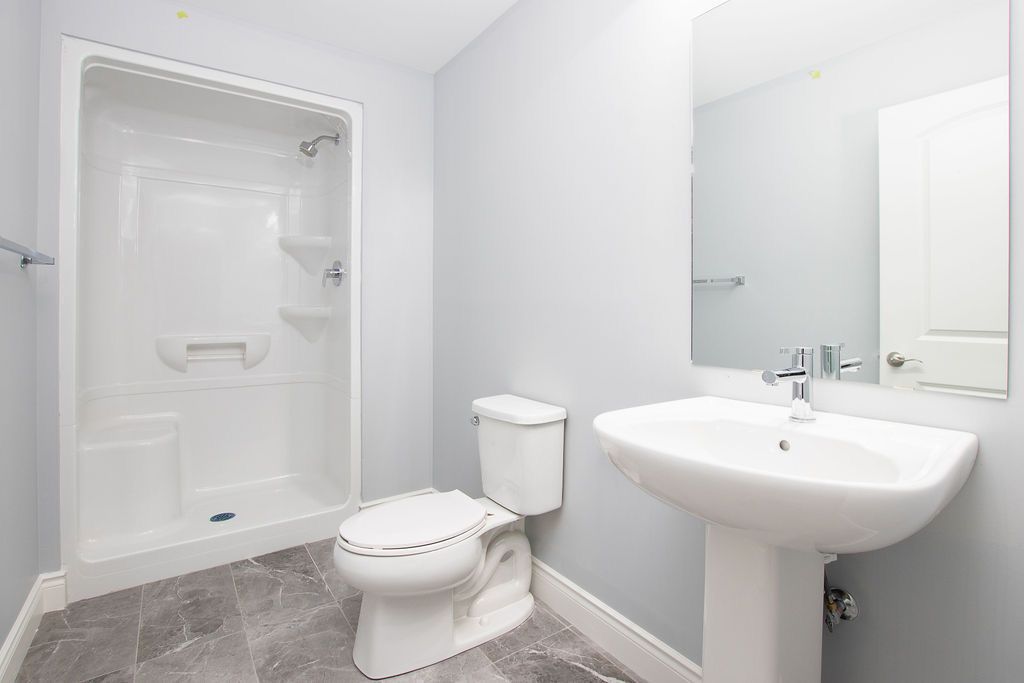 Bathroom with pedestal sink and shower
