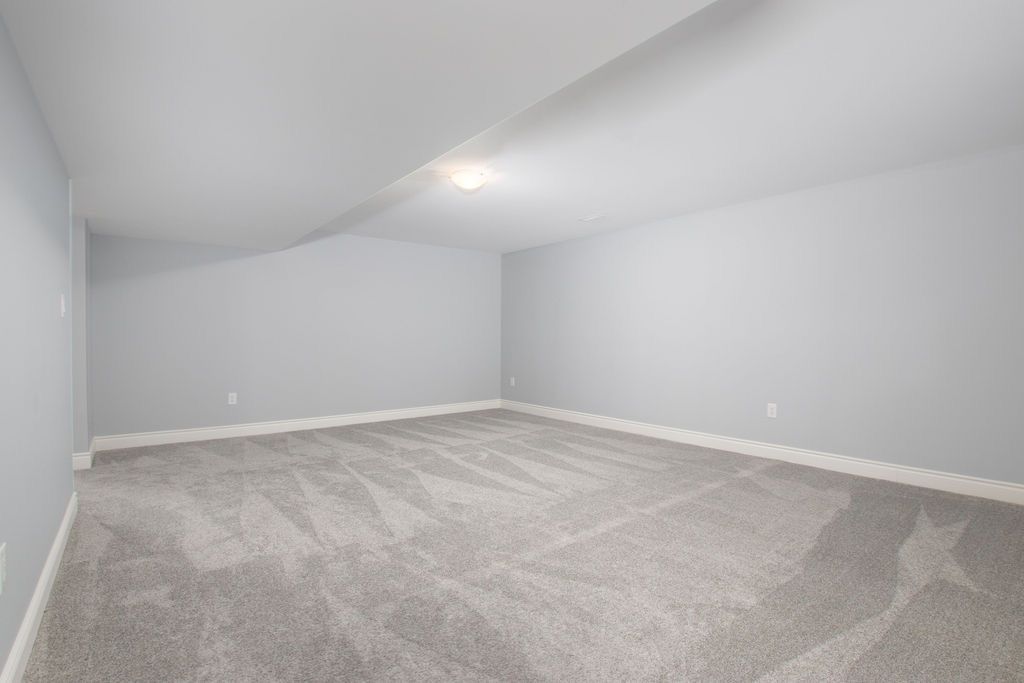 Carpeted room with light grey walls