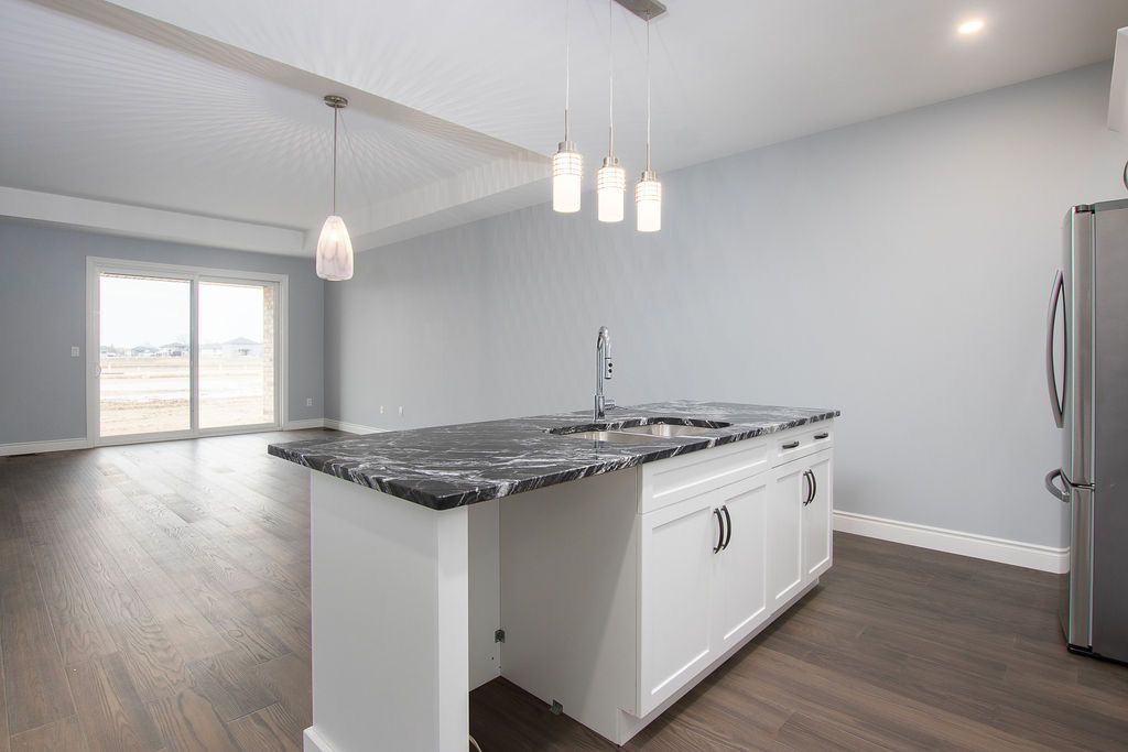 Island with granite countertop and pendant lights