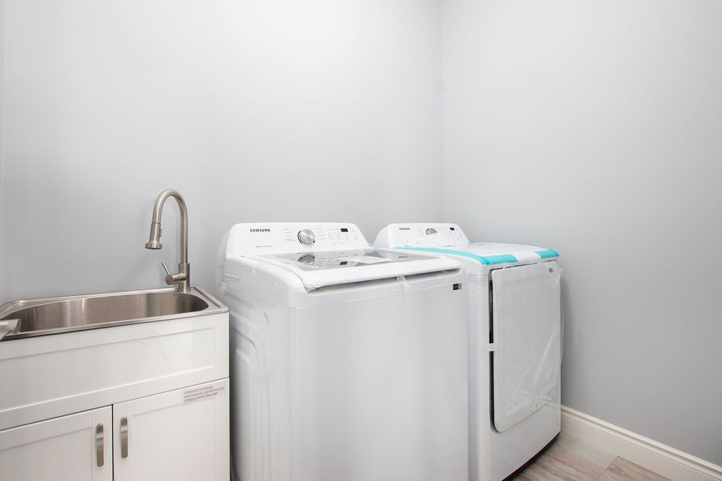 Laundry room with washer, dryer, and utility sink