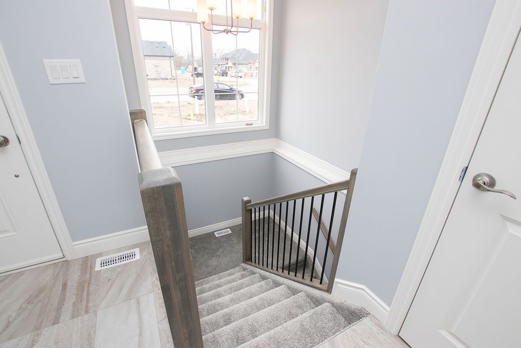 Carpeted staircase with wood and metal railing