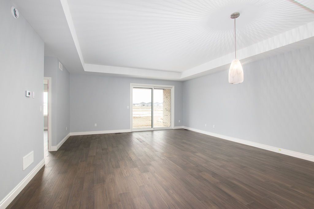 Living room with tray ceiling detail and sliding glass door to backyard