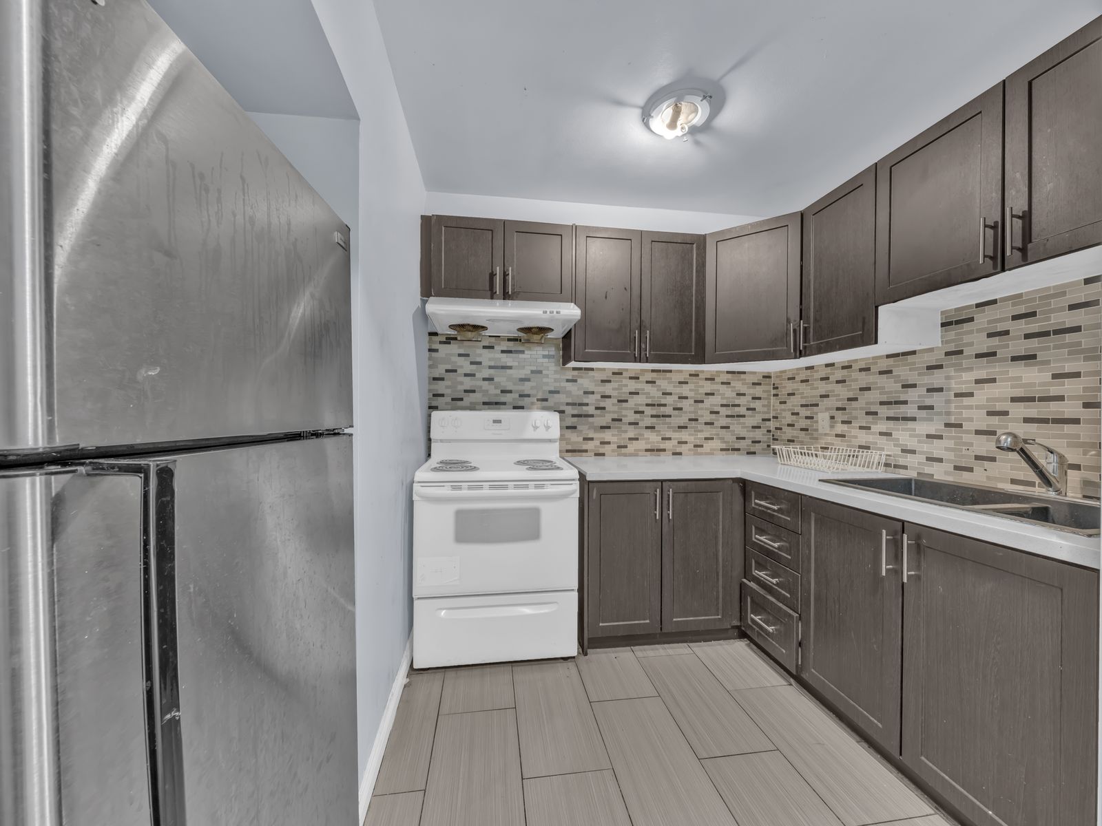 Kitchen with dark cabinets and tiled backsplash