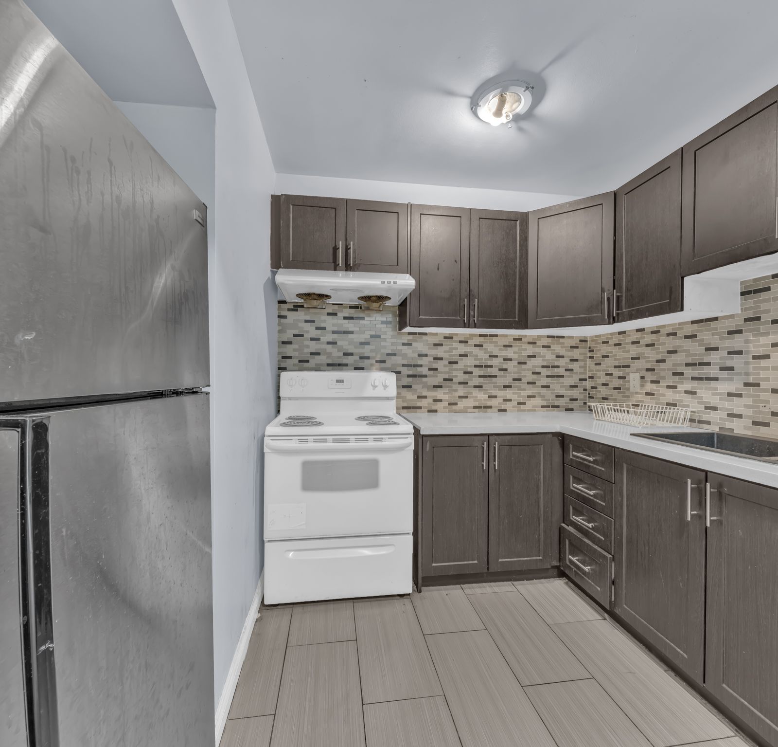 Kitchen with dark cabinets and tiled backsplash