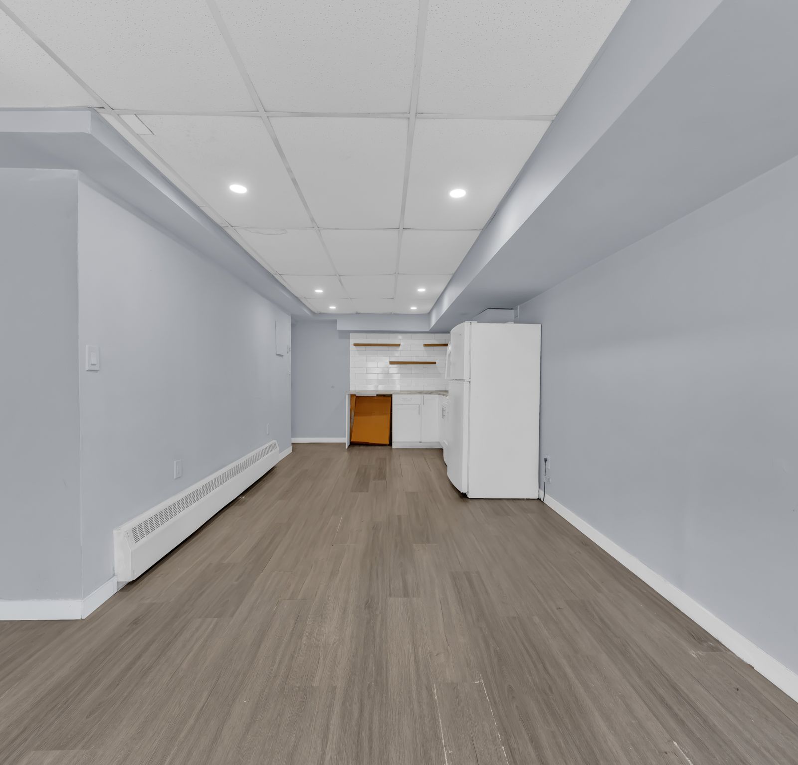 Long living room with grey walls and wood-look flooring