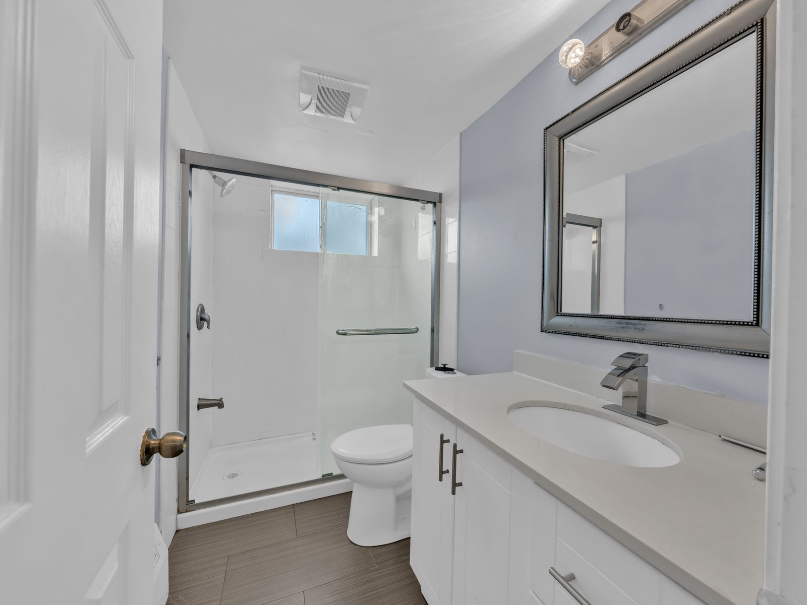 Bathroom with shower, toilet, vanity and large mirror