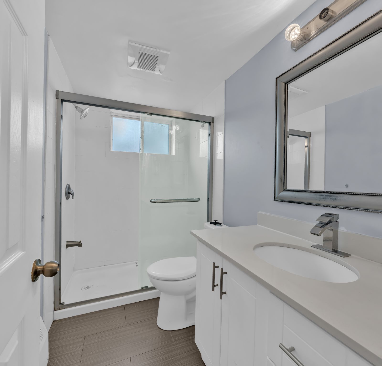 Bathroom with shower, toilet, vanity and large mirror