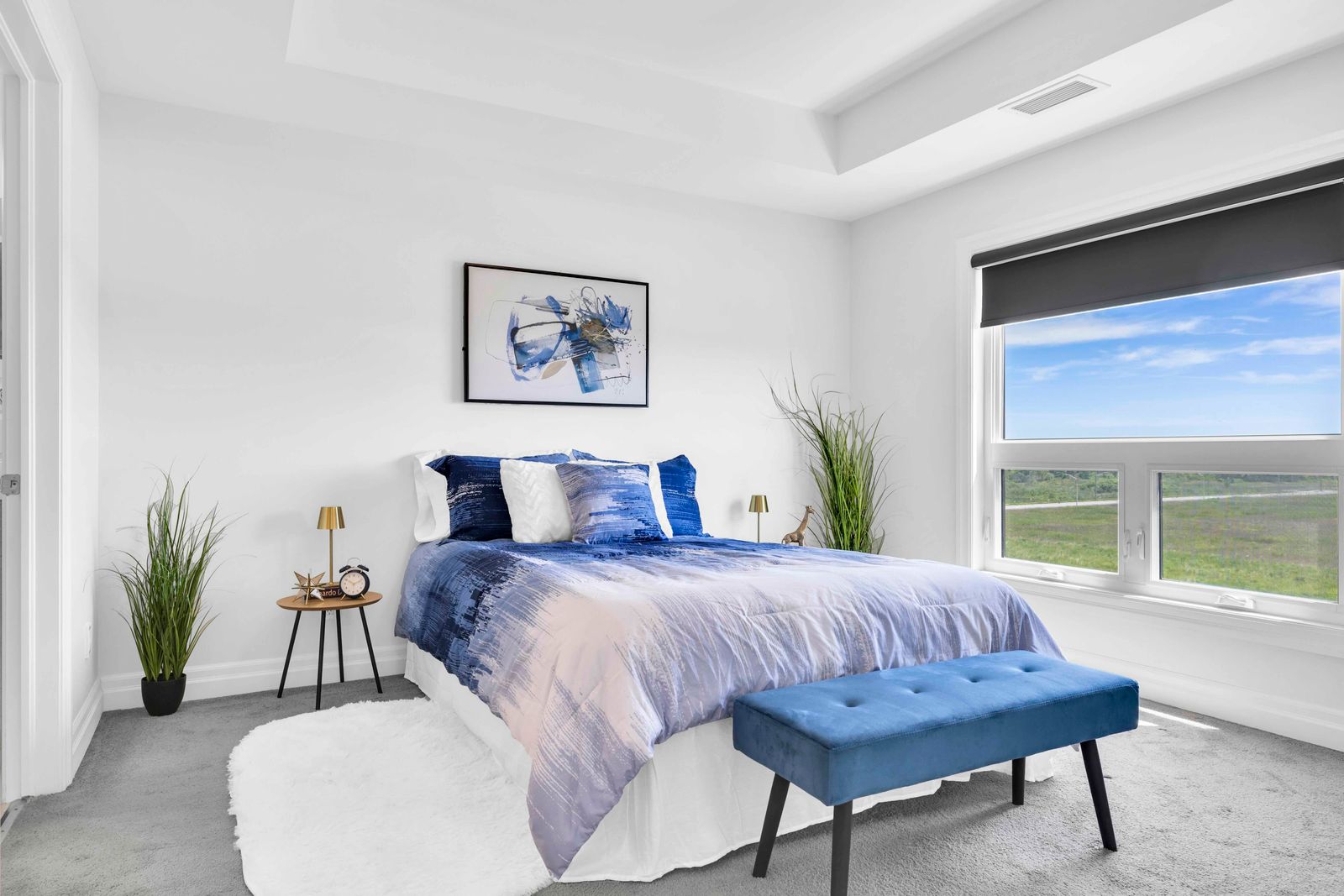 Primary bedroom with large window, open view, and carpeted floor