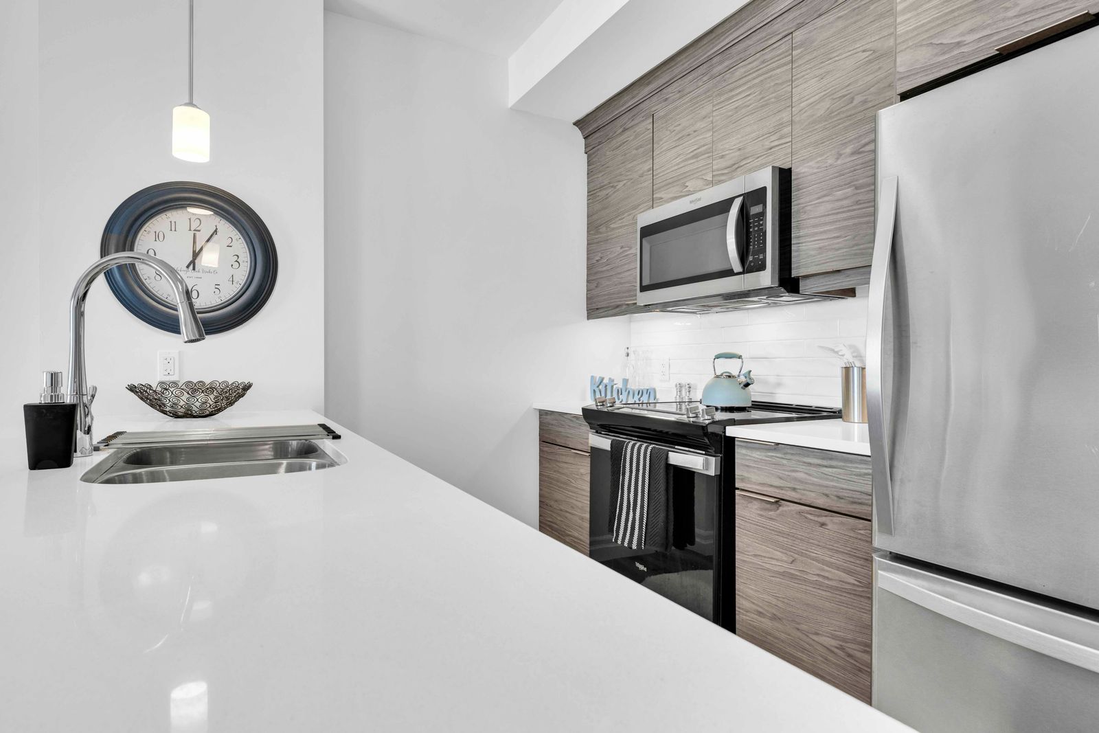 Kitchen countertop, sink, stove, and microwave close-up