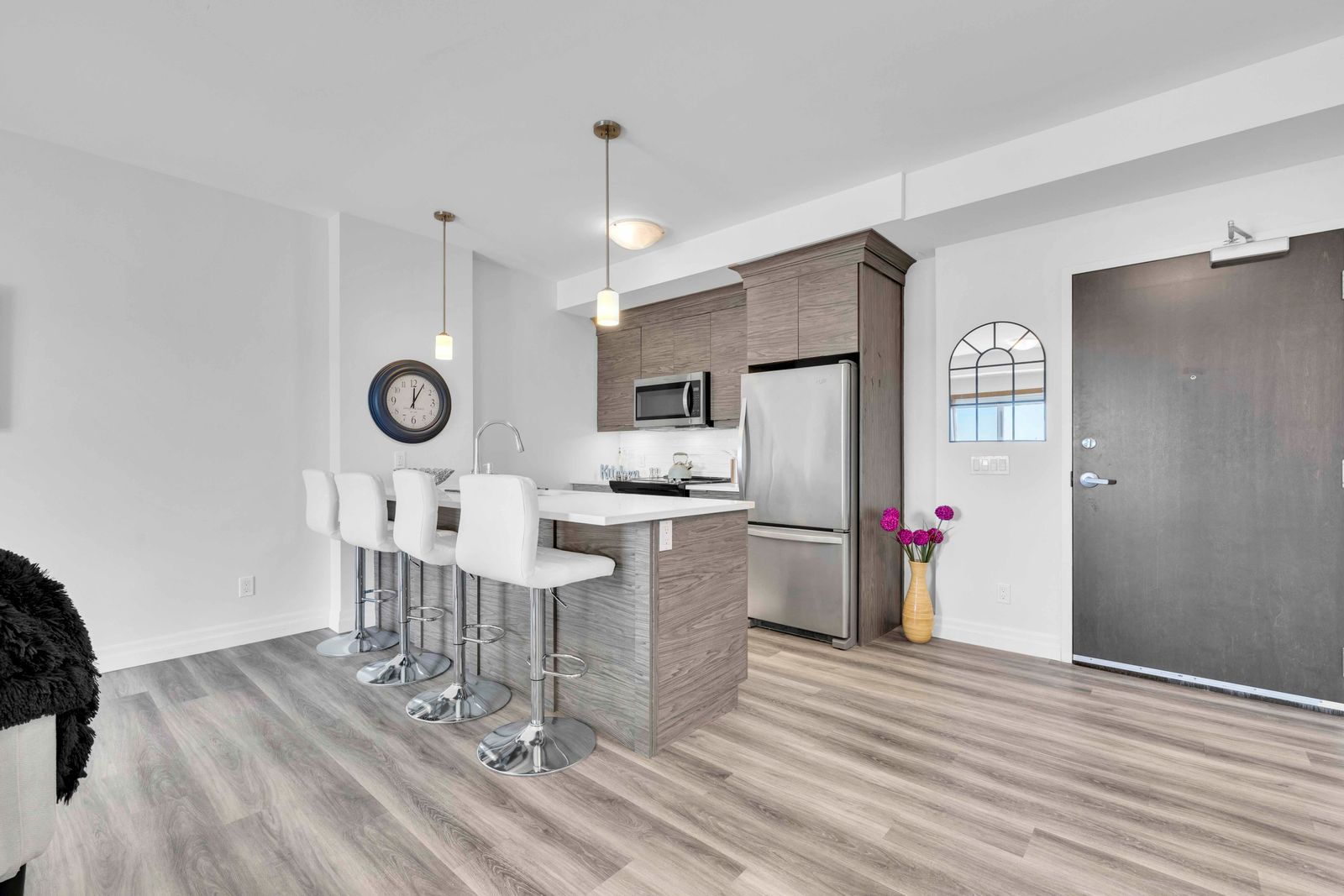 Kitchen island with quartz countertop, bar stools, and pendant lights