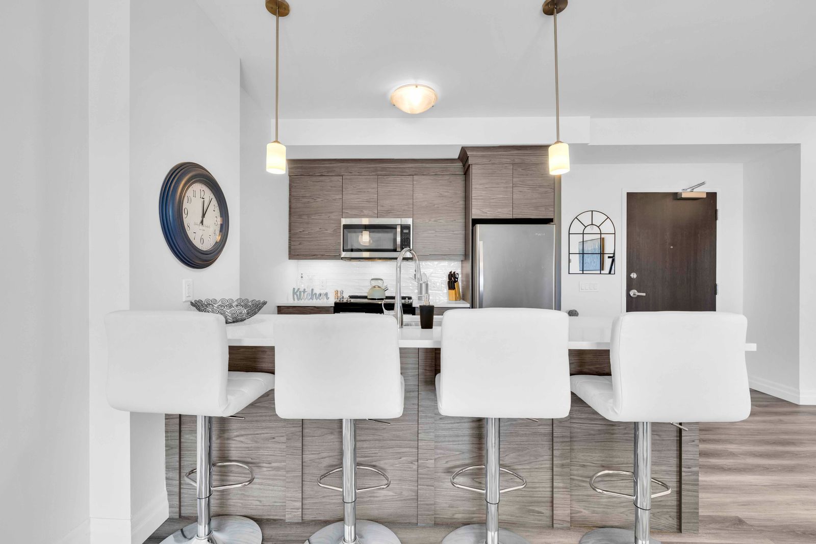 Kitchen island from front showing quartz countertop, sink, and wood-grain cabinetry