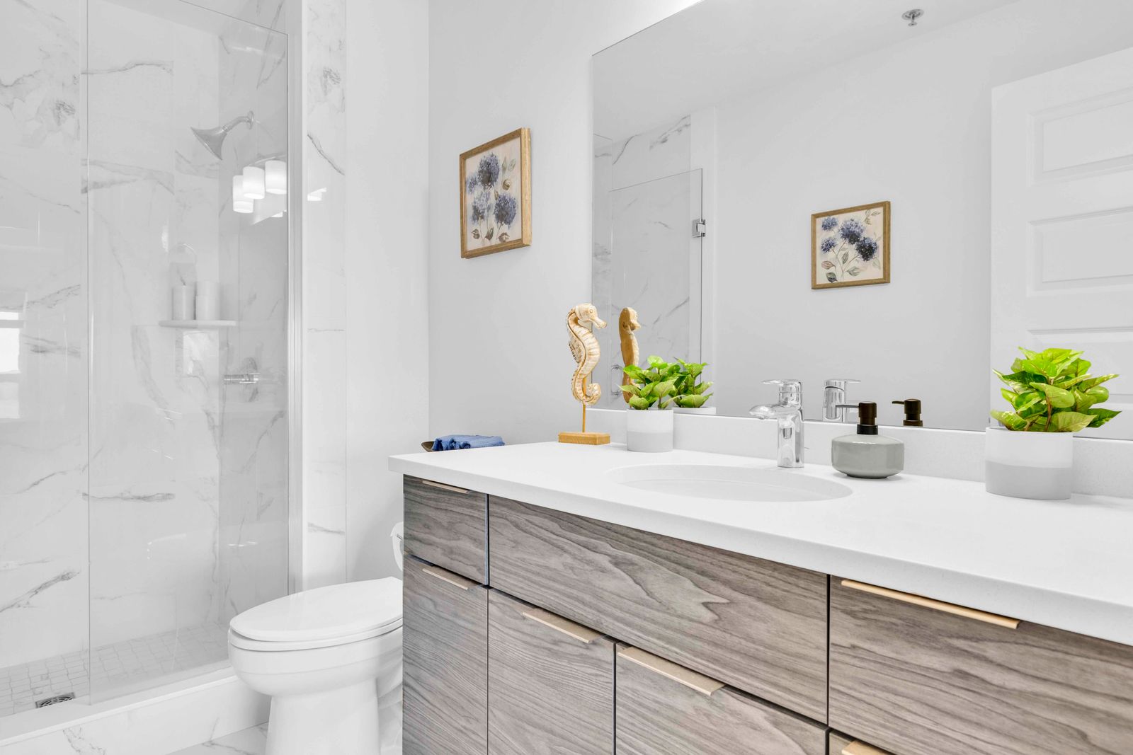 Bathroom with glass shower, wood-finish vanity, and mirror