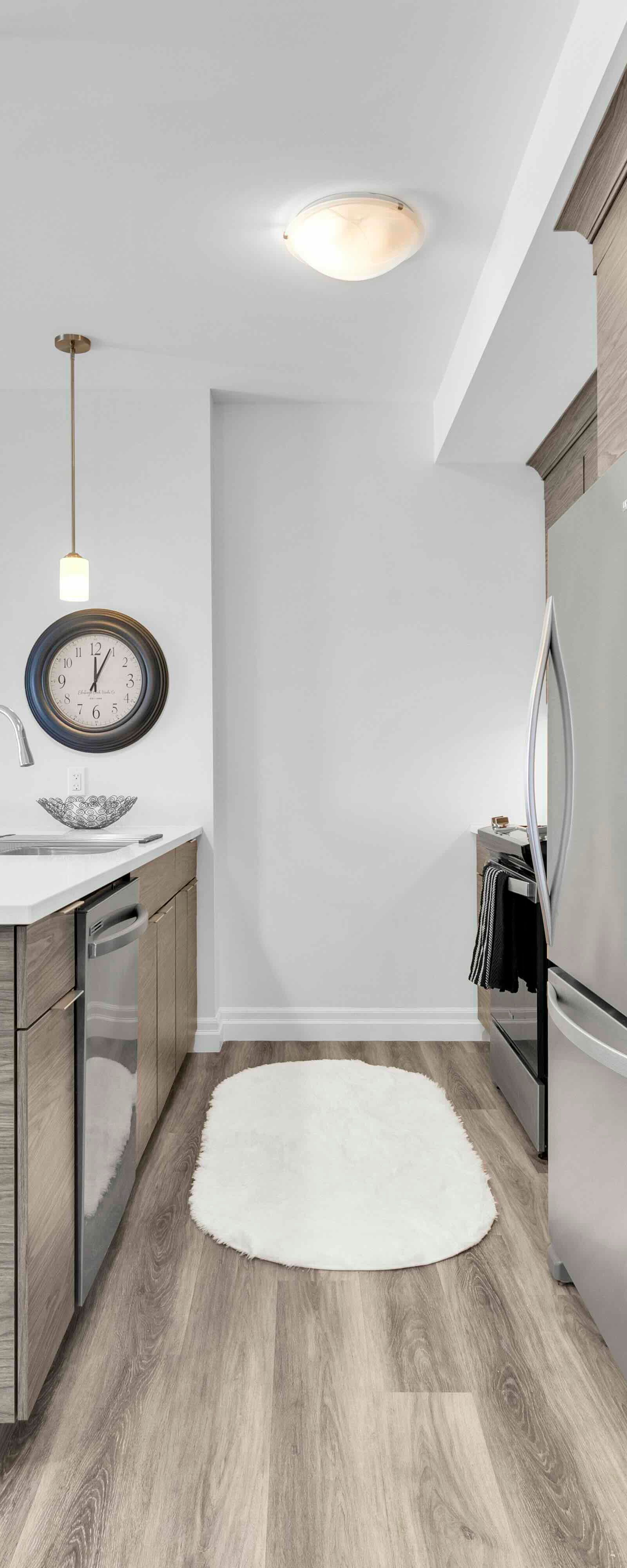 Kitchen island with bar stools, refrigerator, and artwork