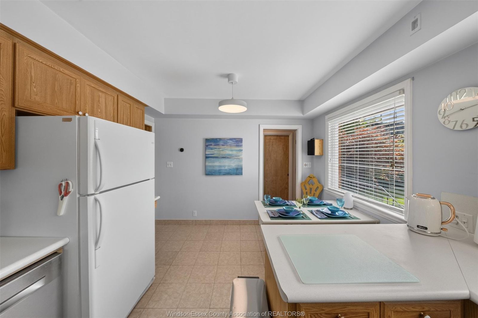 Kitchen with peninsula breakfast bar set for dining and wood cabinetry