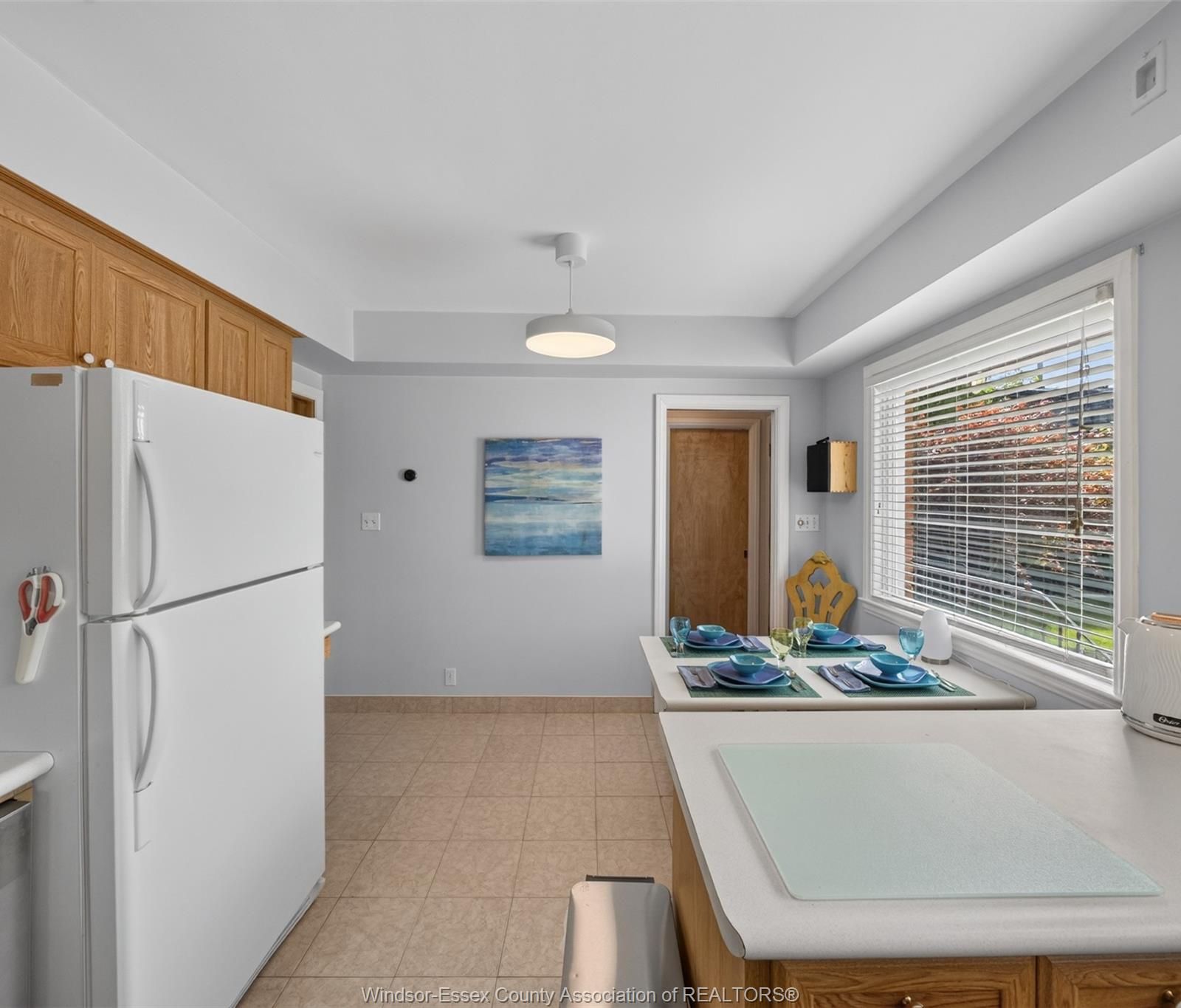 Kitchen with peninsula breakfast bar set for dining and wood cabinetry