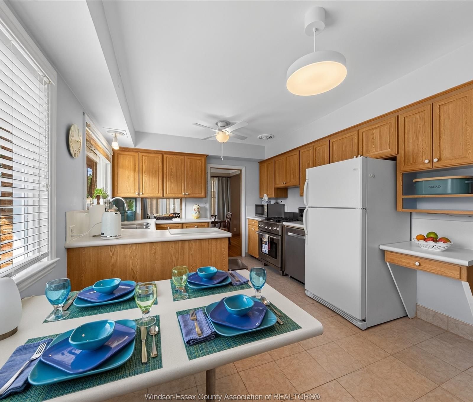 Kitchen with refrigerator, stove, dishwasher and peninsula dining table