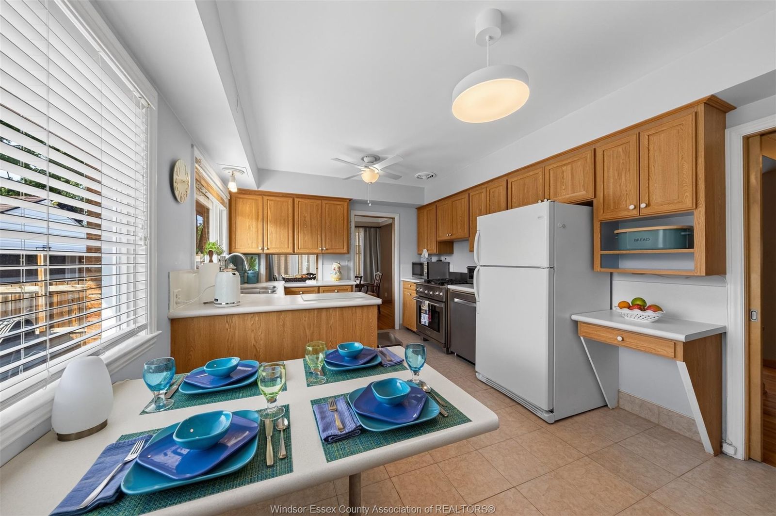 Kitchen with refrigerator, stove, dishwasher and peninsula dining table