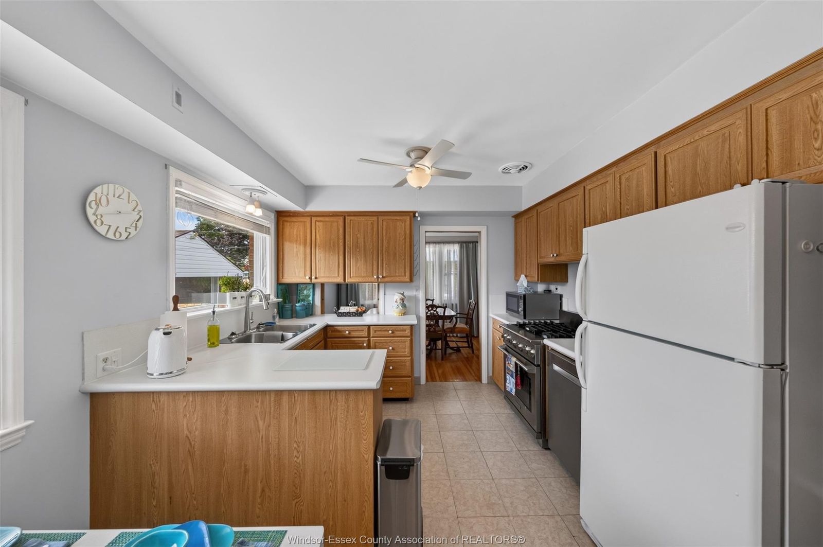 Kitchen sink and cabinetry with ceiling fan and window