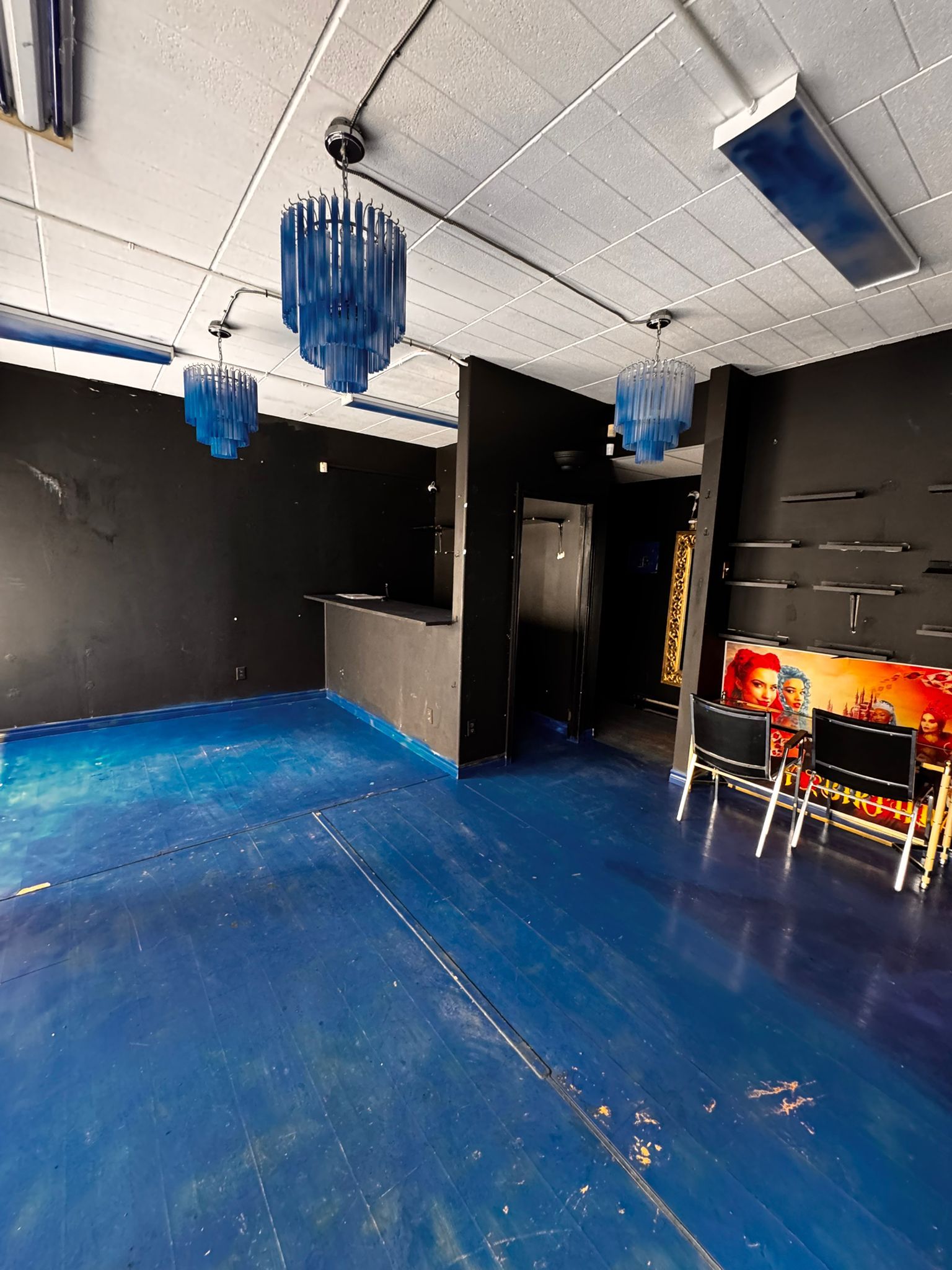 Main floor showing full depth of space with seating area and chandelier cluster