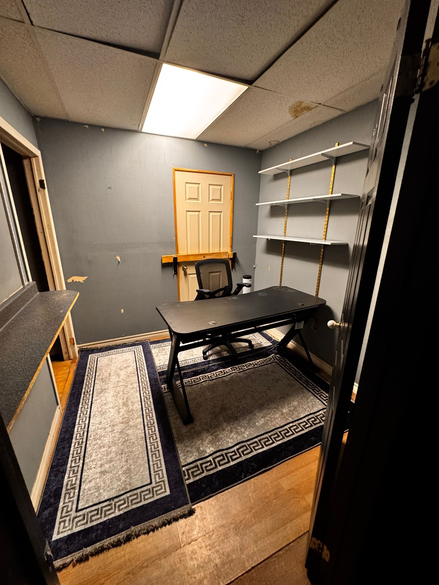 Private back office with desk, shelving, and area rugs